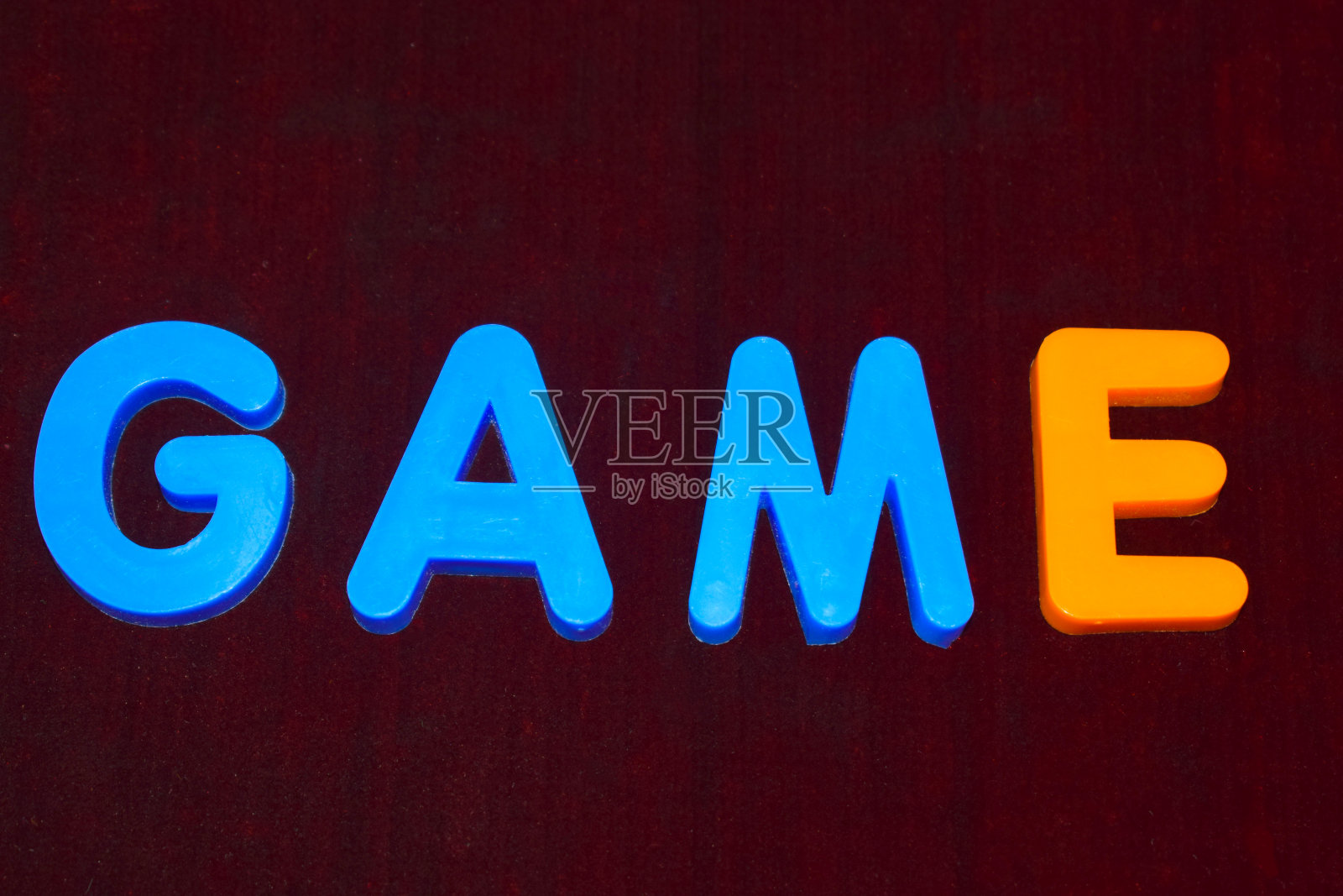 游戏单词写与不同颜色的字母块安排在一个黑暗的背景照片摄影图片