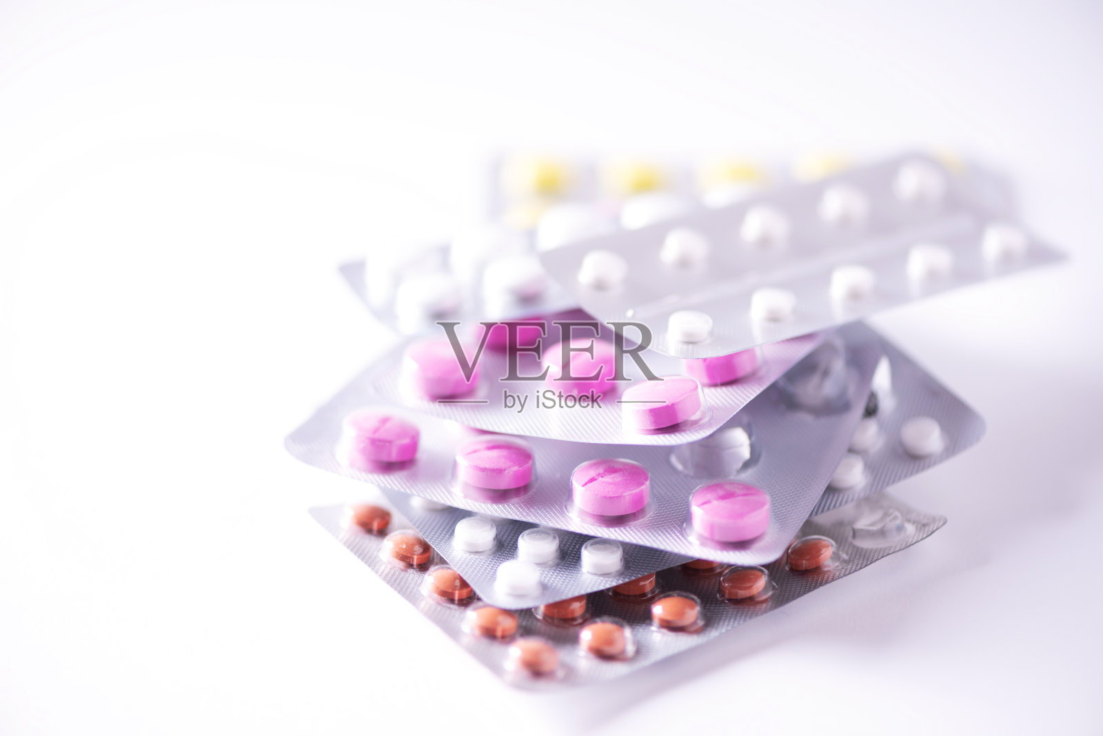 多色药丸，白色背景上的水泡。副本的空间。一堆药治疗感冒冠状病毒Covid-19。照片摄影图片