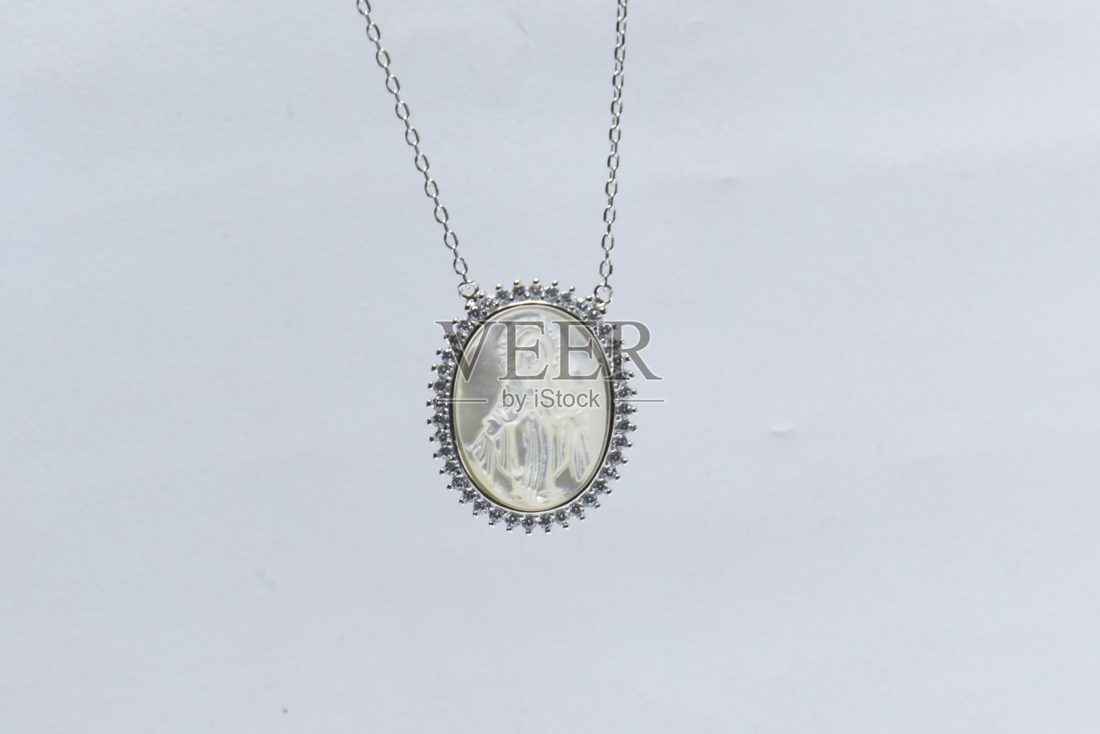 白色背景上银链吊坠照片摄影图片