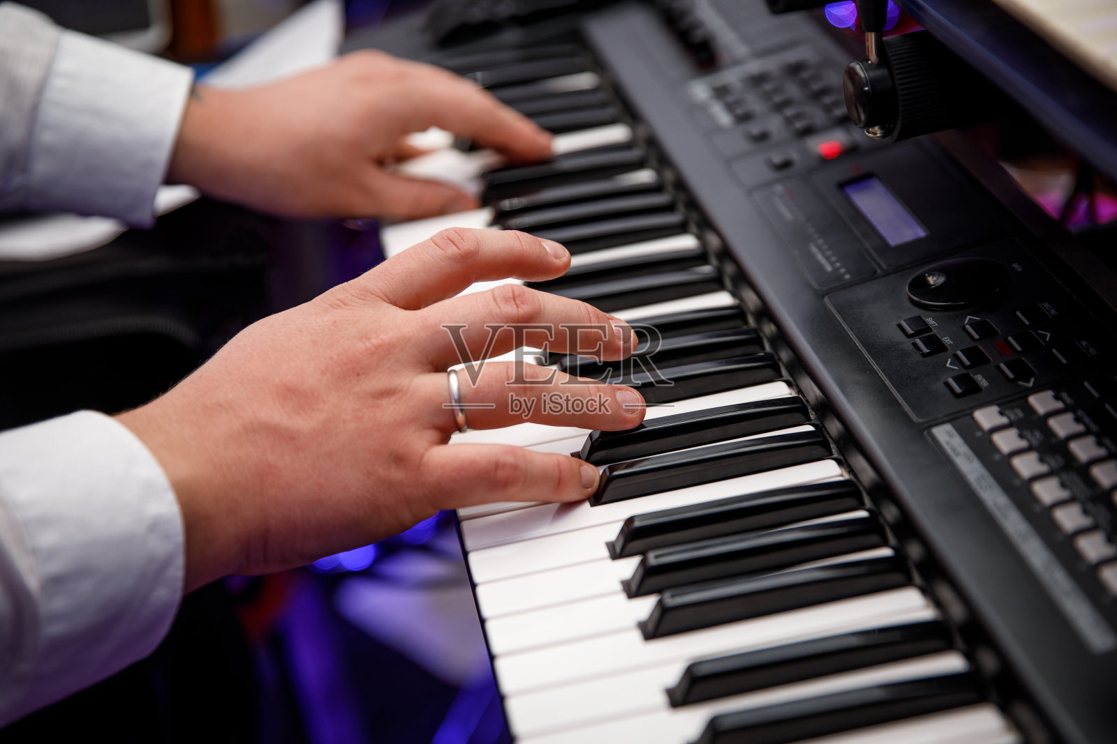 一个男人在玩电子合成器。手指在键盘上。照片摄影图片