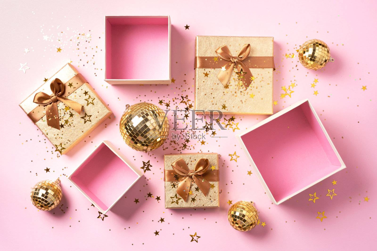 礼盒，闪光的黄金迪斯科球，闪闪发光的黄金在粉红色的背景。新年装饰品，星光闪耀。新年、圣诞节、情人节的问候概念。复制文本。俯视图，平放。照片摄影图片