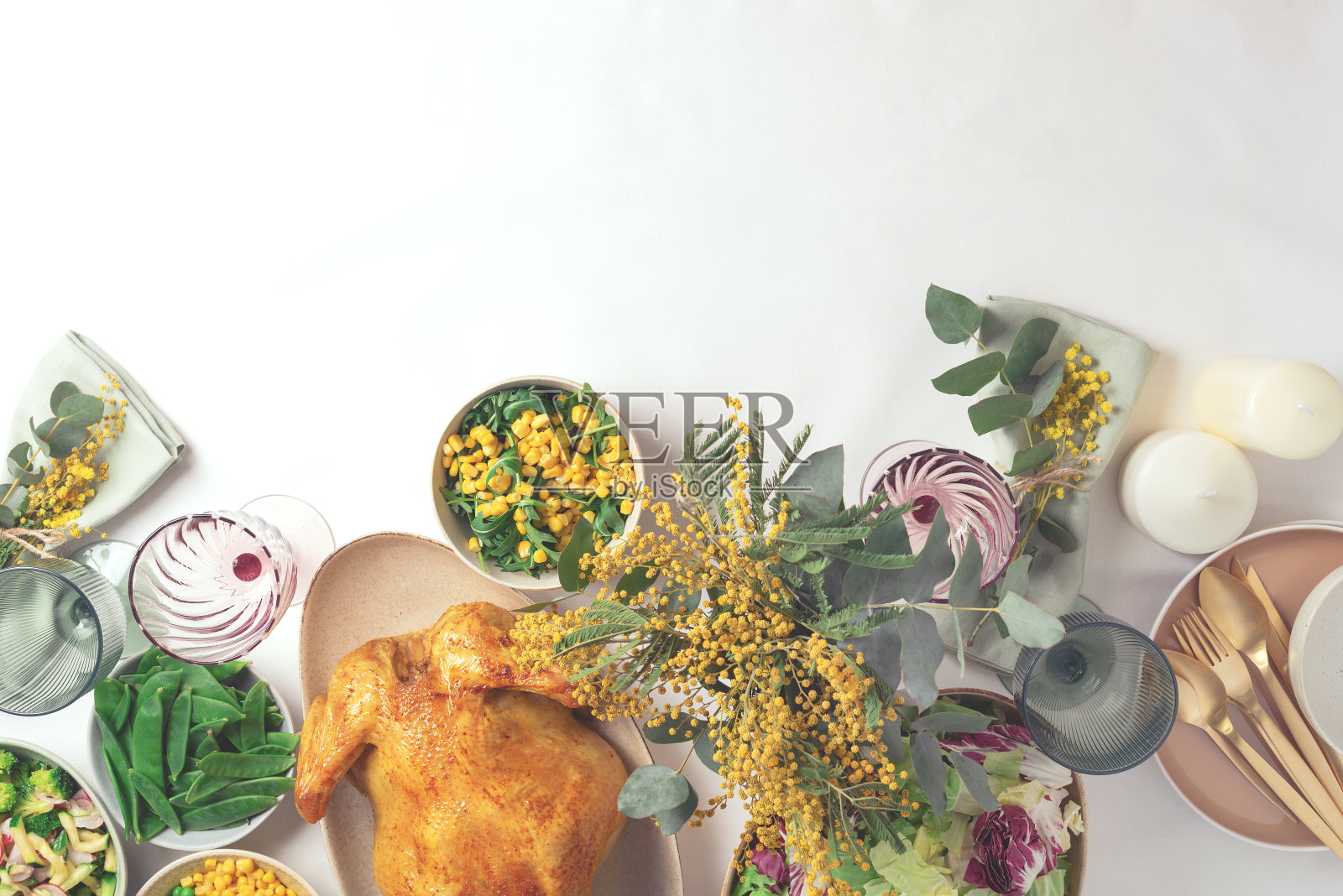 节日家庭餐桌。盛有沙拉和蔬菜的盘子，碗，小吃，烤鸡，桉树，含苞欲放的花在白色的背景。情人节，妇女节，母亲节，婚礼早午餐，节日家庭午餐照片摄影图片