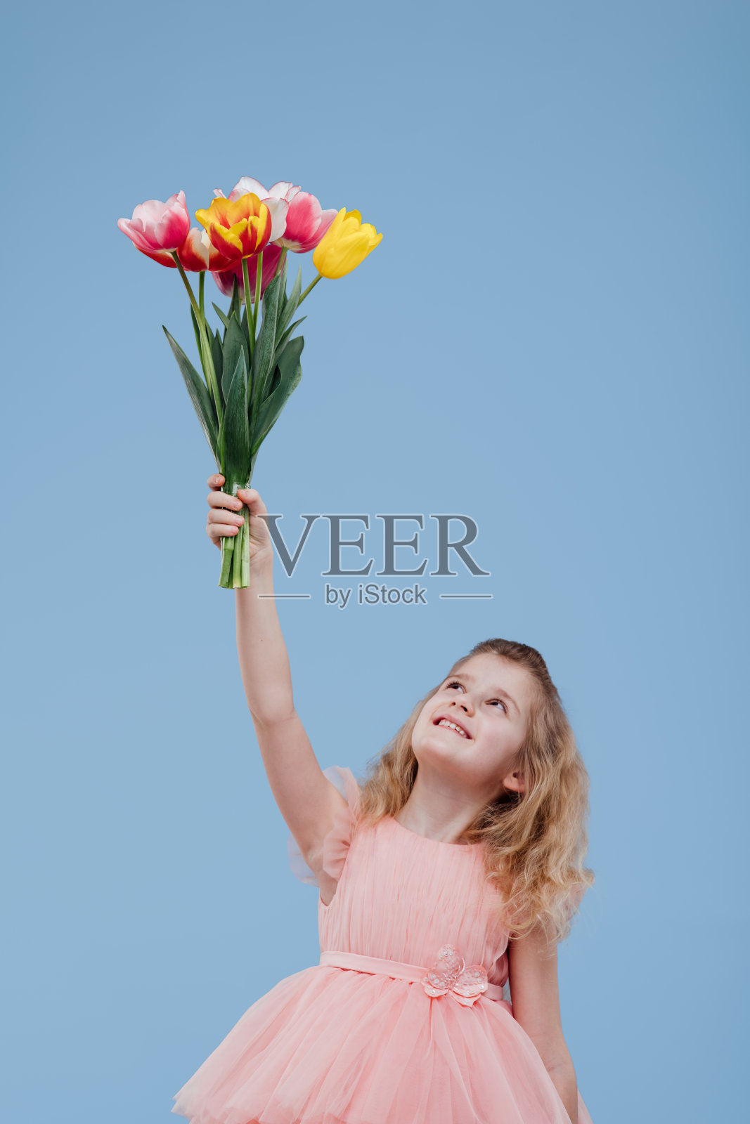 快乐的女孩举起手捧着一束鲜花照片摄影图片