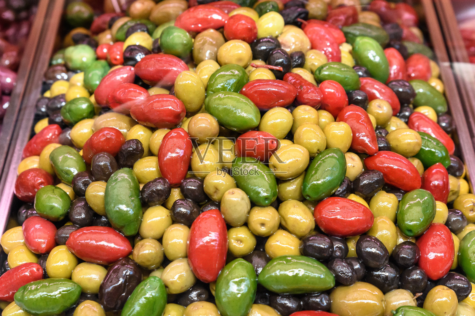 黄色，绿色，红色和黑色的新鲜有机油在木桶里，在街头食品市场出售，健康的希腊素食照片的软焦点照片摄影图片