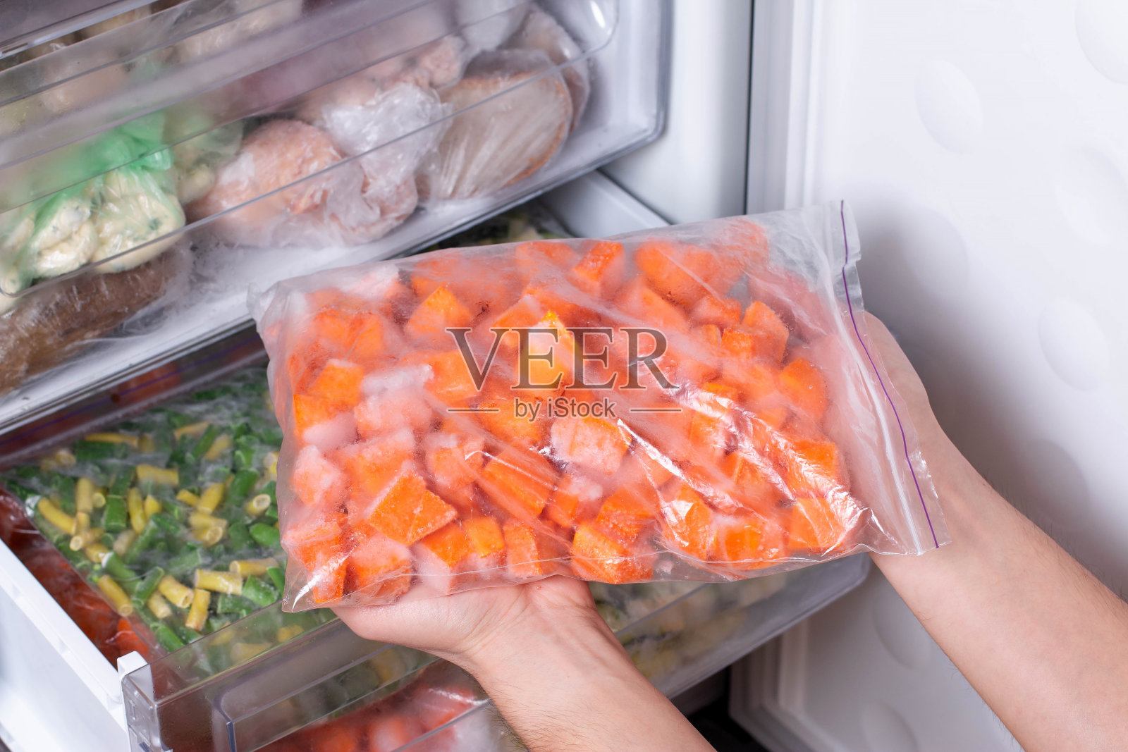 冰箱里的袋装冷冻蔬菜。冷冻南瓜立方体照片摄影图片