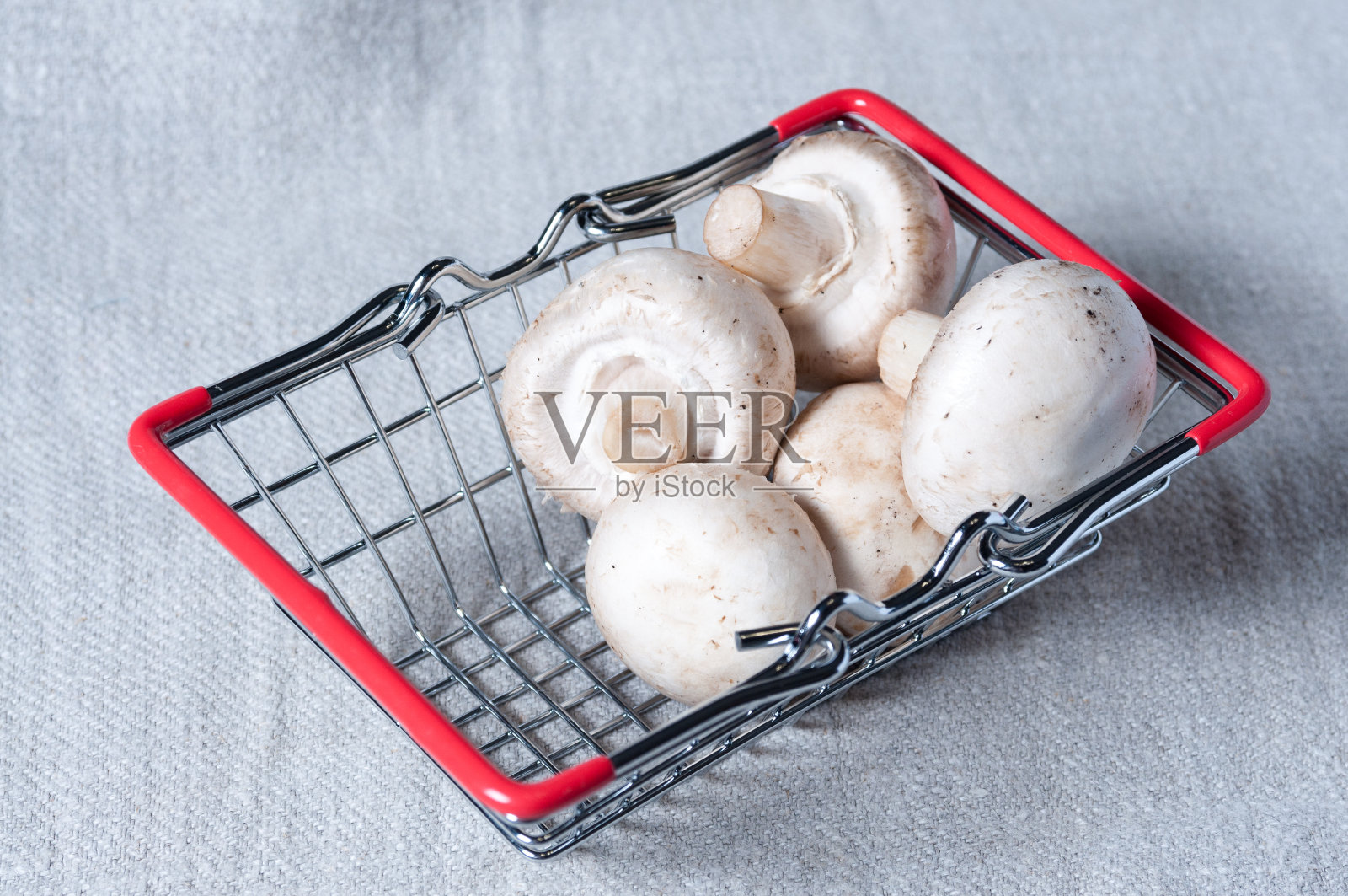 新鲜的蘑菇，迷你购物篮里的蘑菇。关闭照片摄影图片