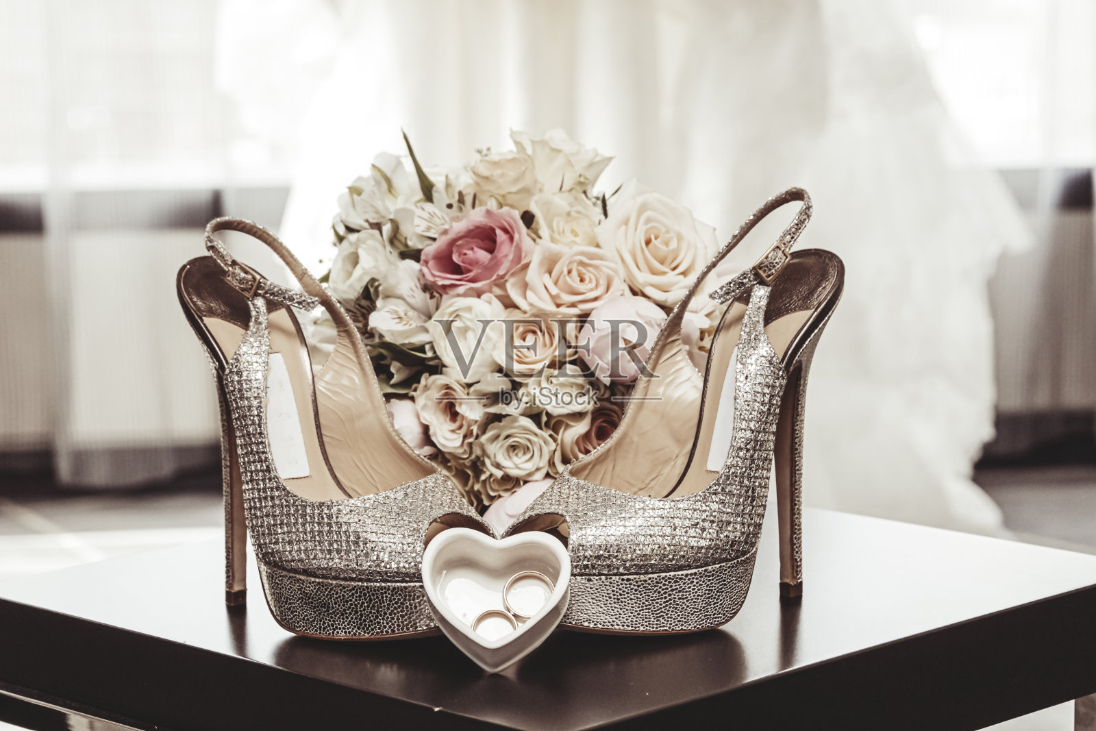 婚礼安排:一束新娘花束、一双高跟鞋和一个装有结婚戒指的心形盒子照片摄影图片