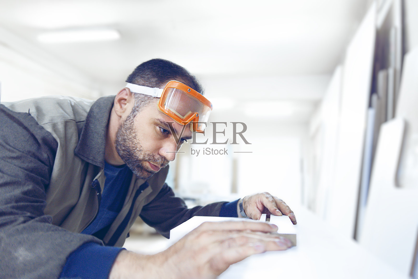 木匠用防护眼镜对白色光泽的三聚氰胺进行质量控制照片摄影图片