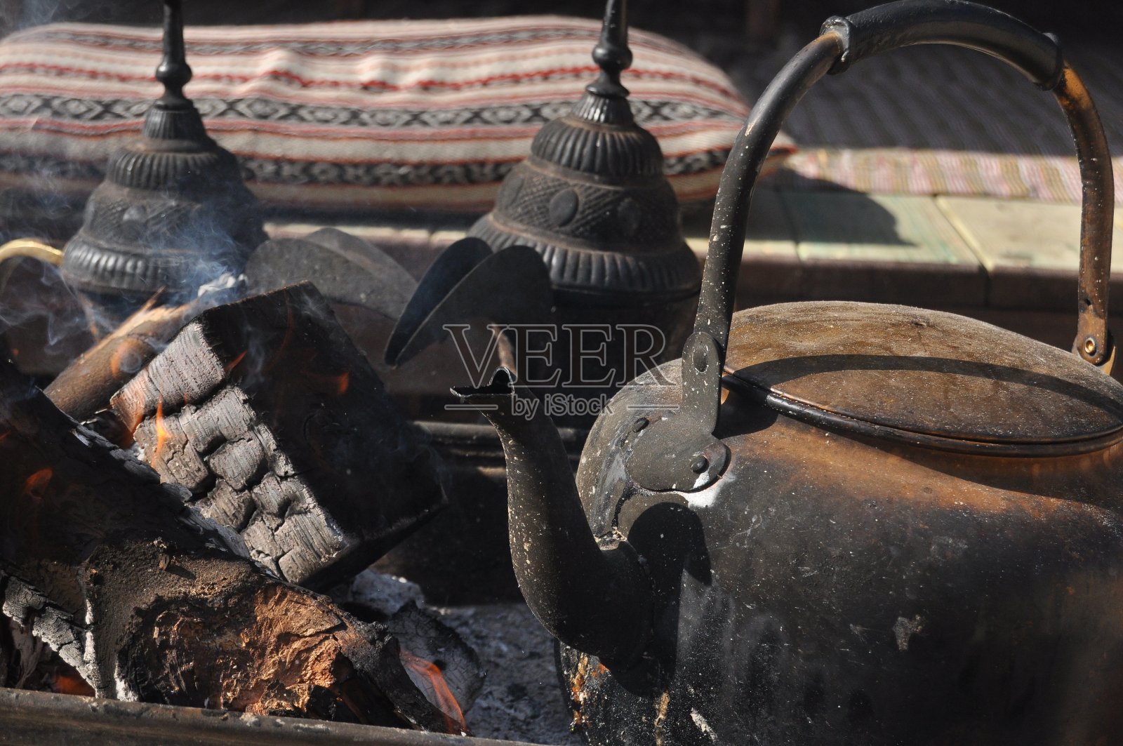 在以色列耶路撒冷山坡上，一个烧焦的水壶在发光的木头上为游客煮咖啡。照片摄影图片
