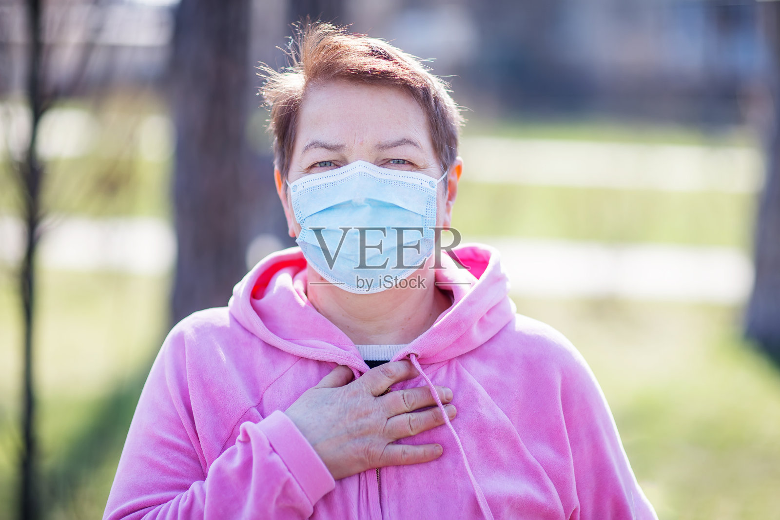 在户外戴口罩的资深妇女照片摄影图片