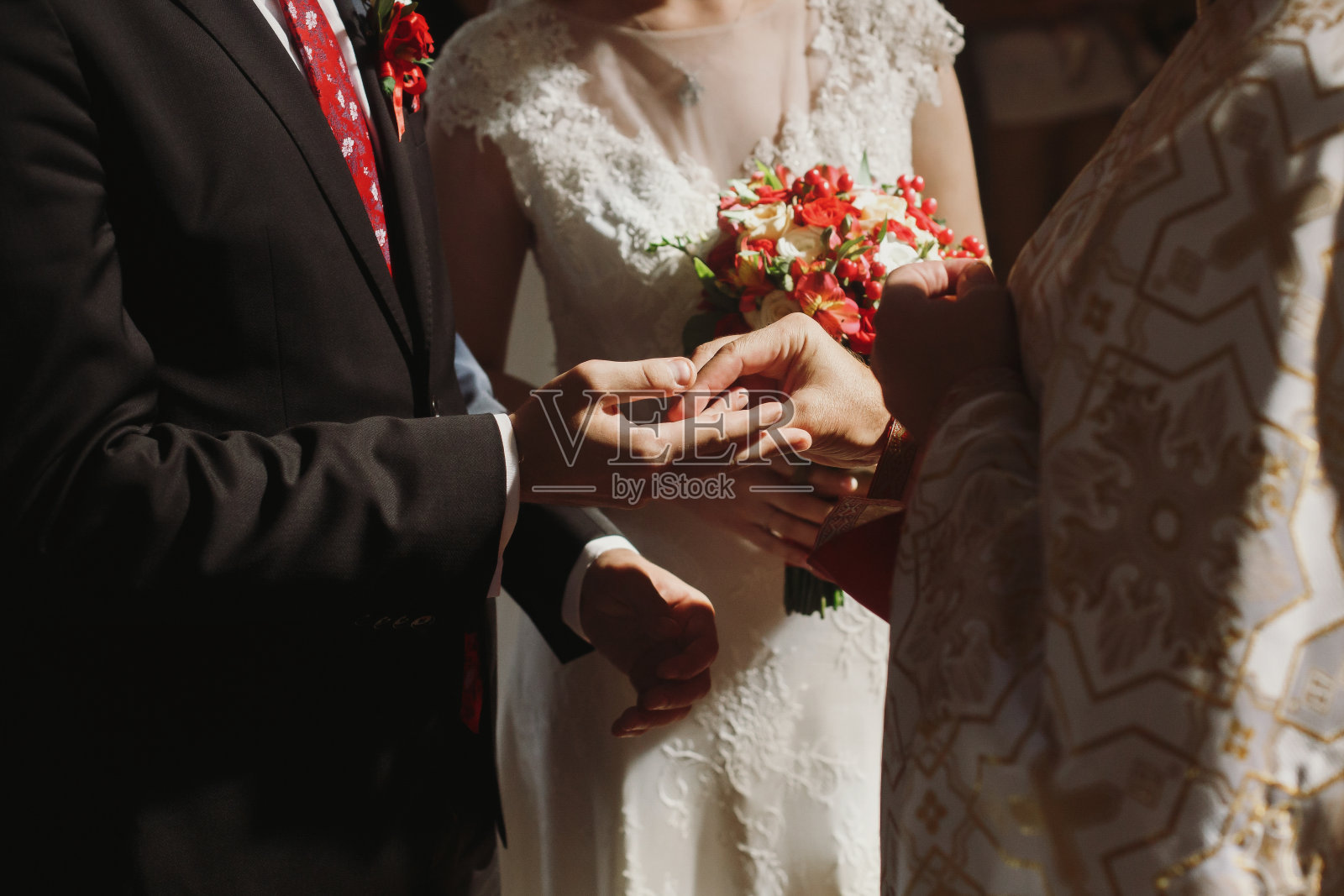 浪漫情侣在教堂婚礼上交换戒指，新郎将结婚戒指戴在新娘手上照片摄影图片