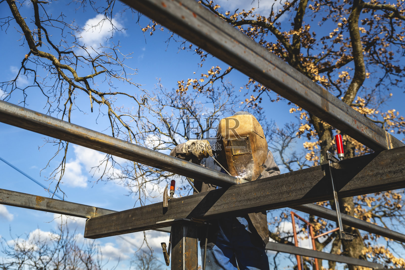 焊接工人焊接屋顶支柱照片摄影图片