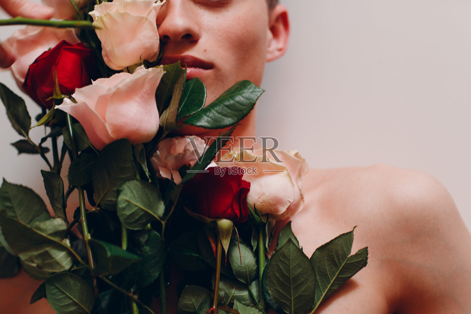 年轻的男模特带着花。美丽的肖像。照片摄影图片