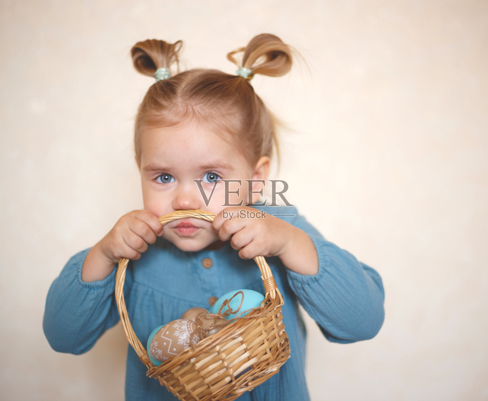 金发碧眼的女孩，穿着一件古色古香的衣服，手里拿着一篮子复活节彩蛋照片摄影图片