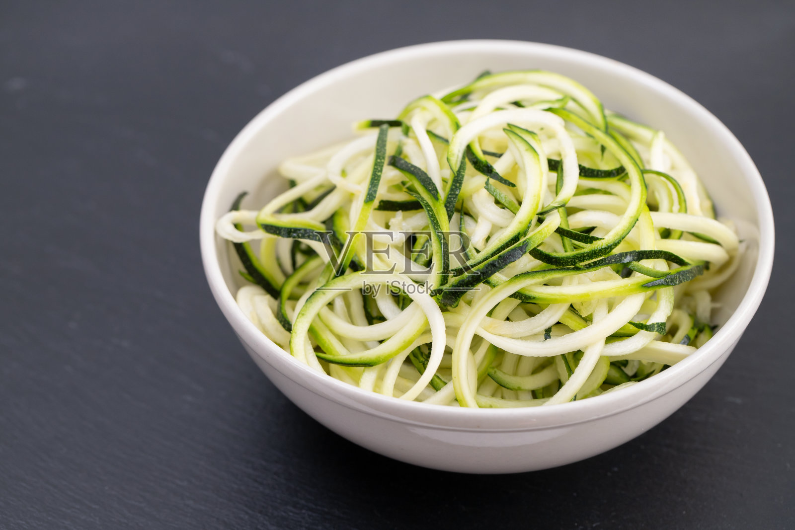 黑色背景碗里的小胡瓜面照片摄影图片