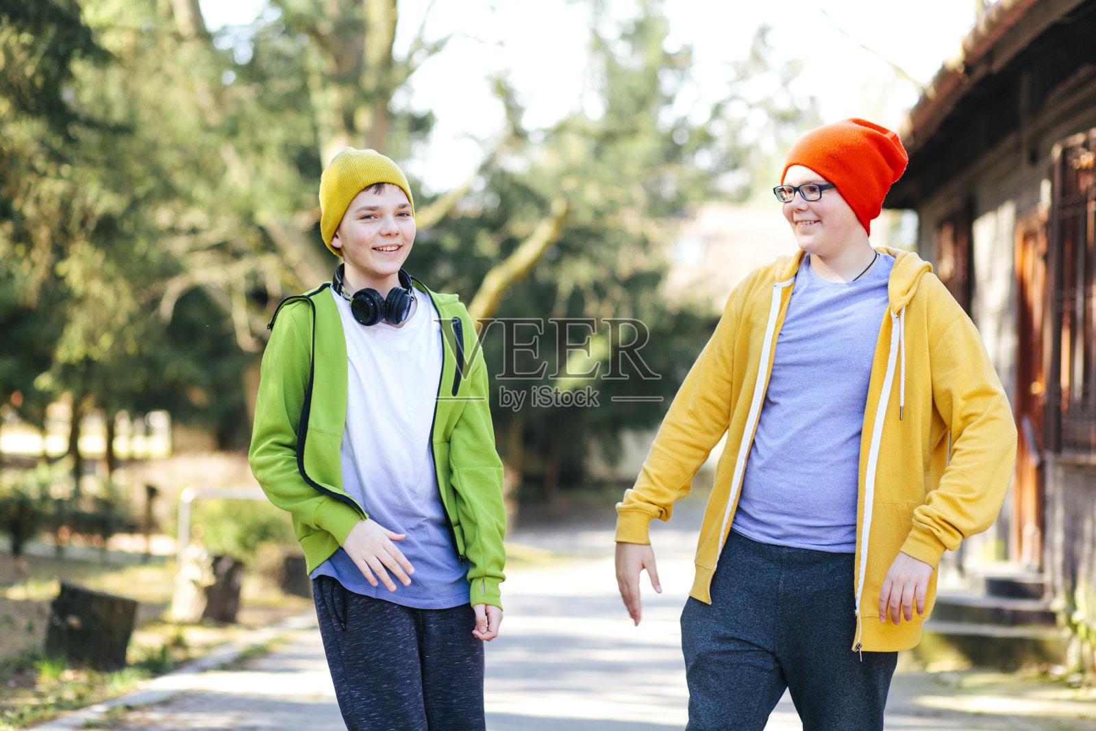 两个可爱的十几岁的男孩调皮，快乐，大笑，快乐地站在一起在阳光灿烂的公园照片摄影图片