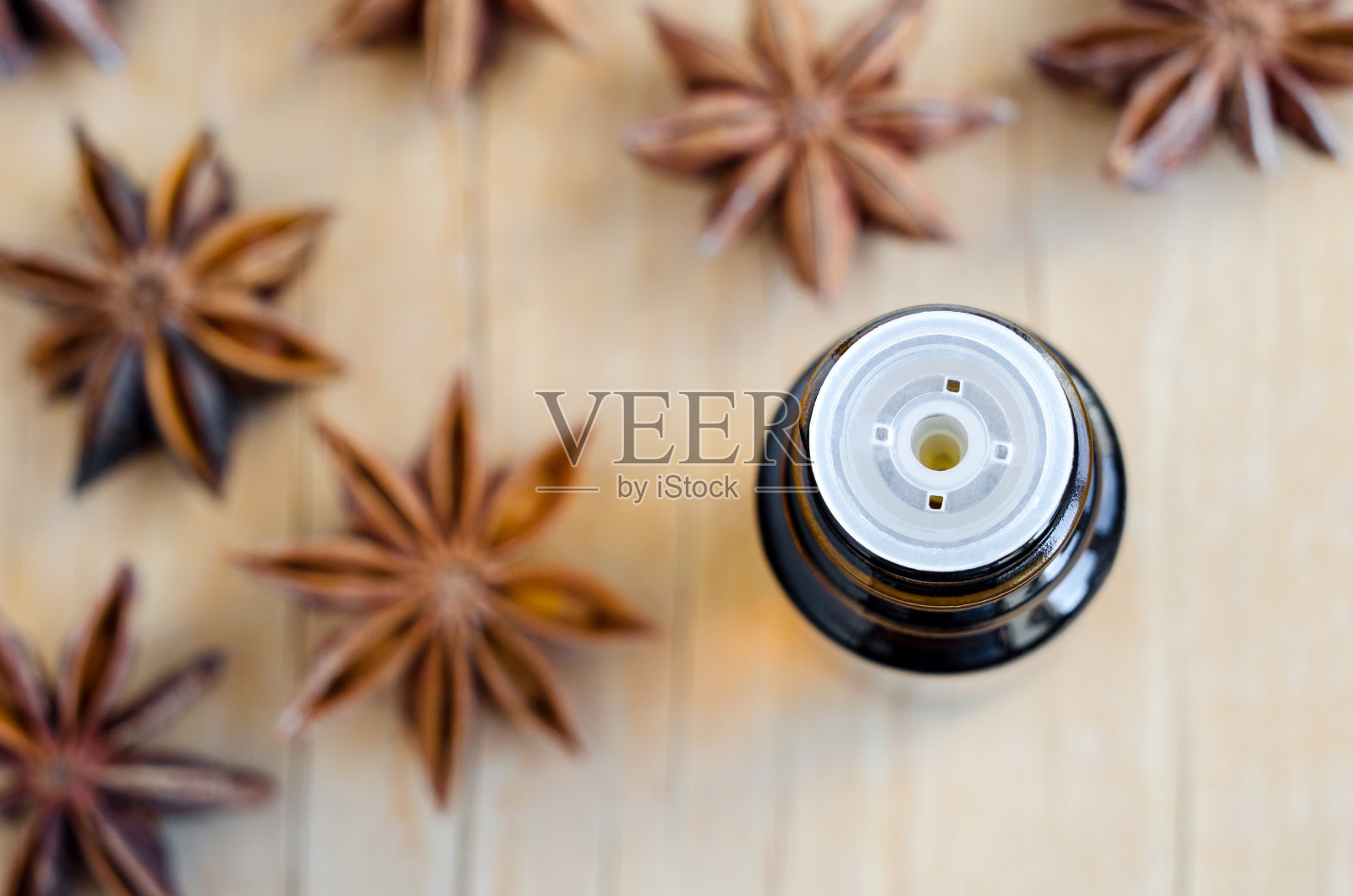 小瓶八角精油。芳香疗法，草药和水疗成分。木制背景。俯视图，复制空间。照片摄影图片