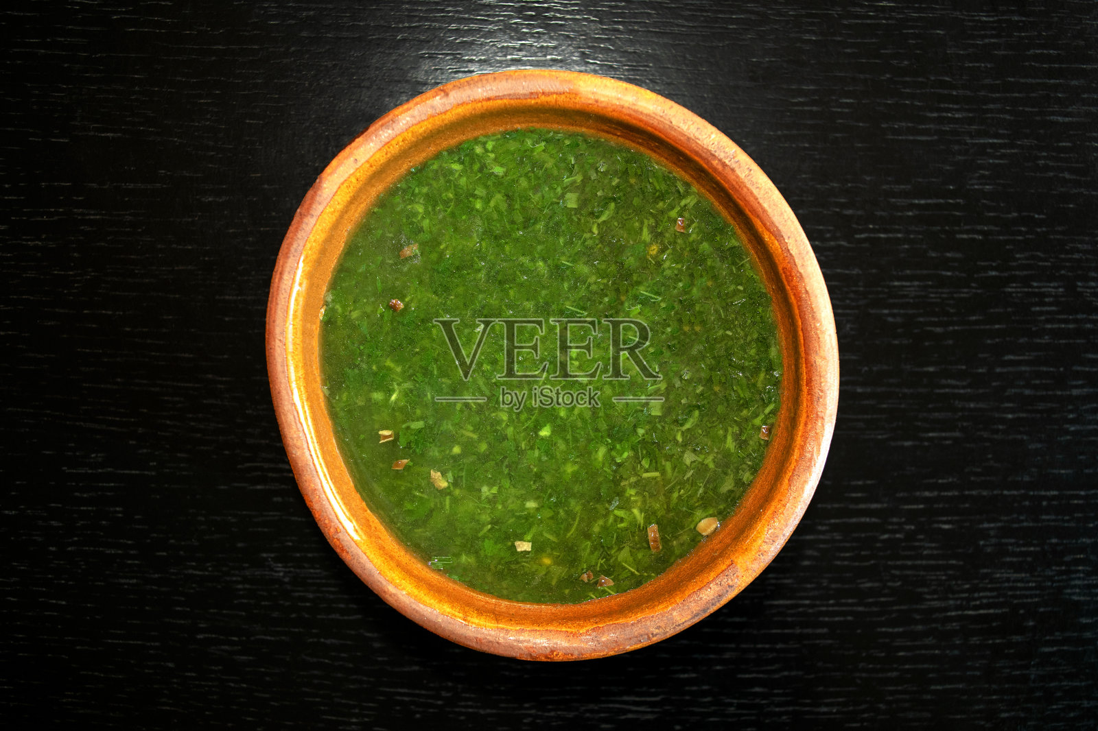 深色木质背景上的棕色碗盛的埃及锦葵汤照片摄影图片