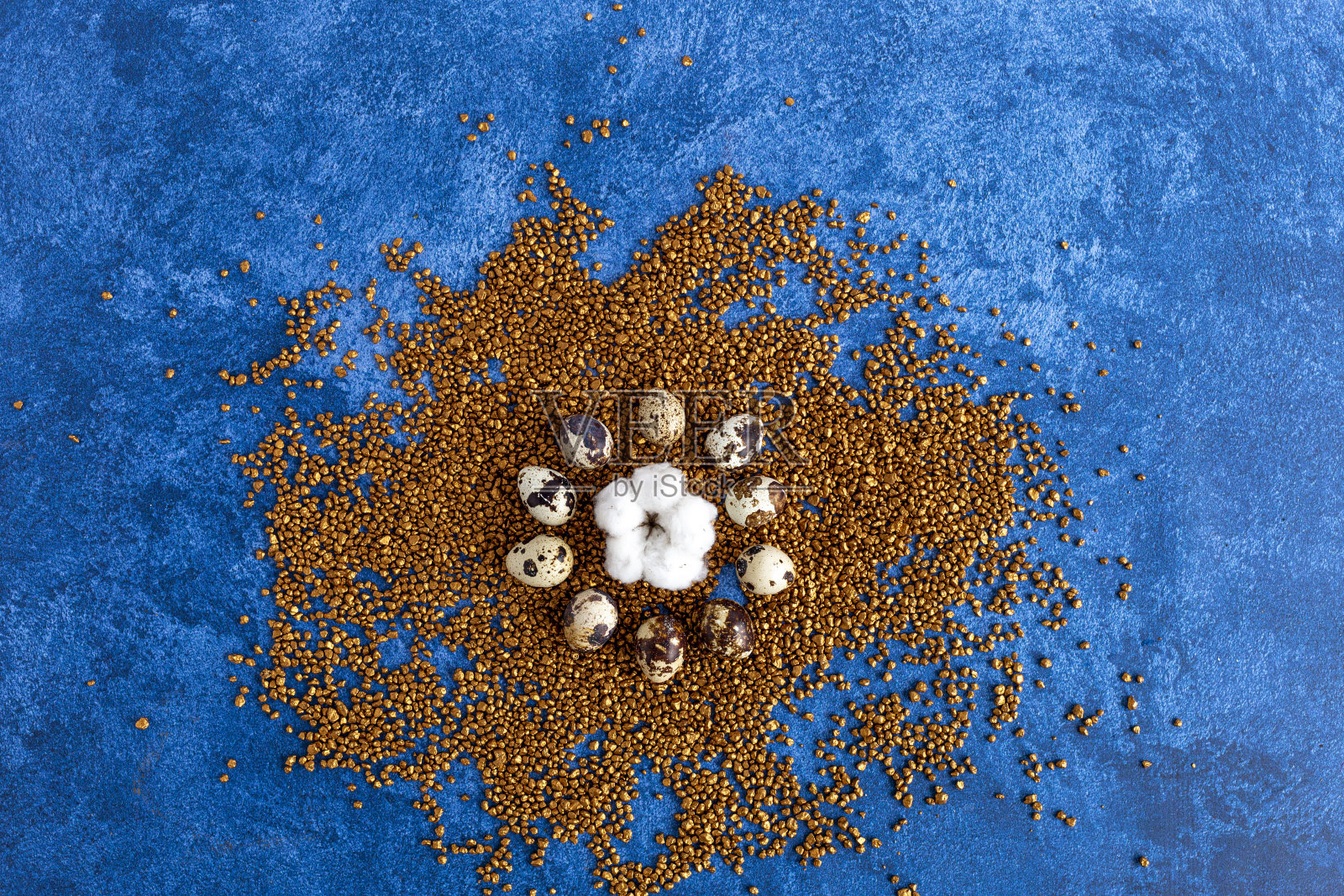 鹌鹑复活节彩蛋在金色的装饰岩石上。深蓝色的背景。节日装饰，复活节的概念背景。照片摄影图片