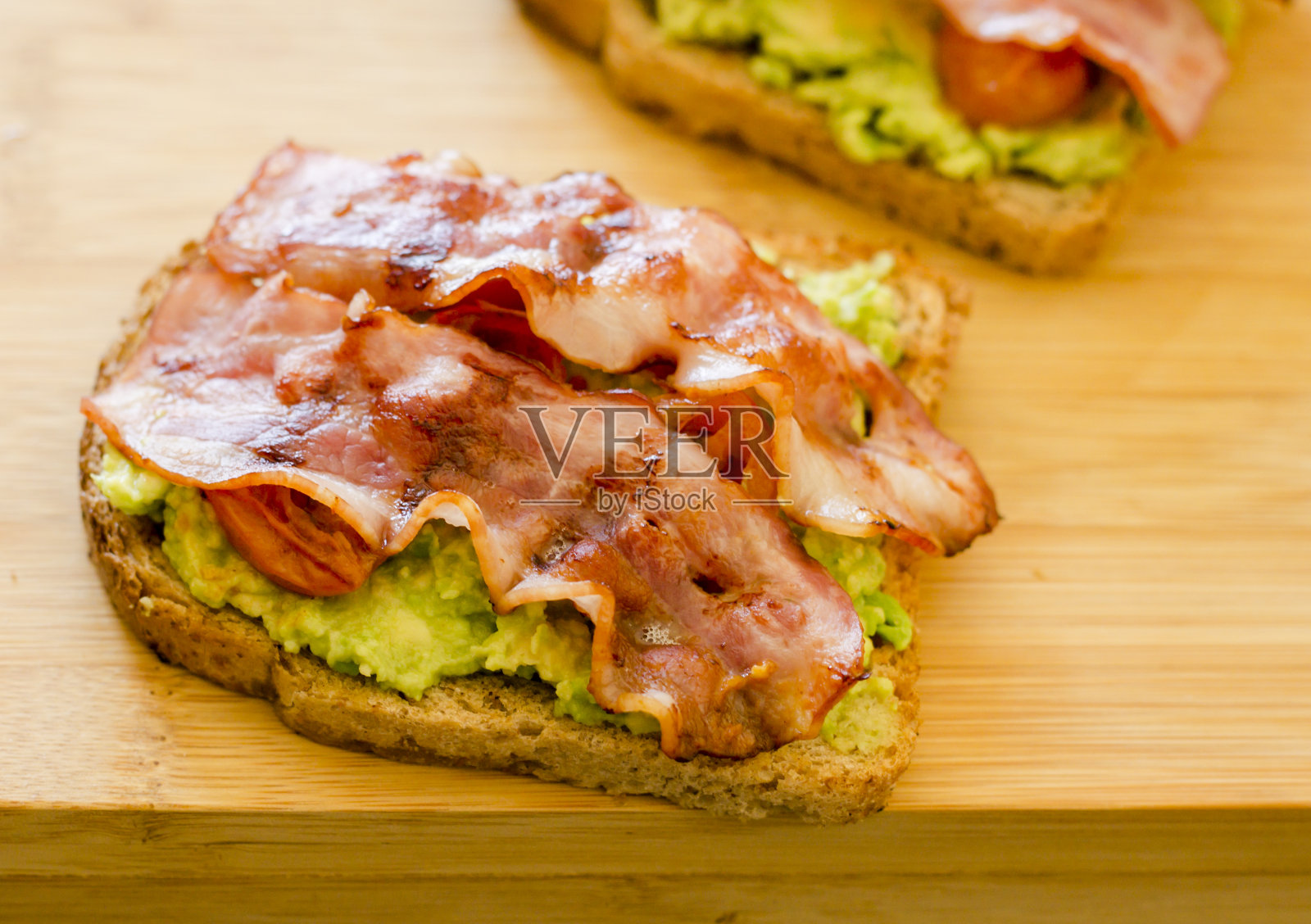 牛油果吐司配樱桃、西红柿和培根照片摄影图片