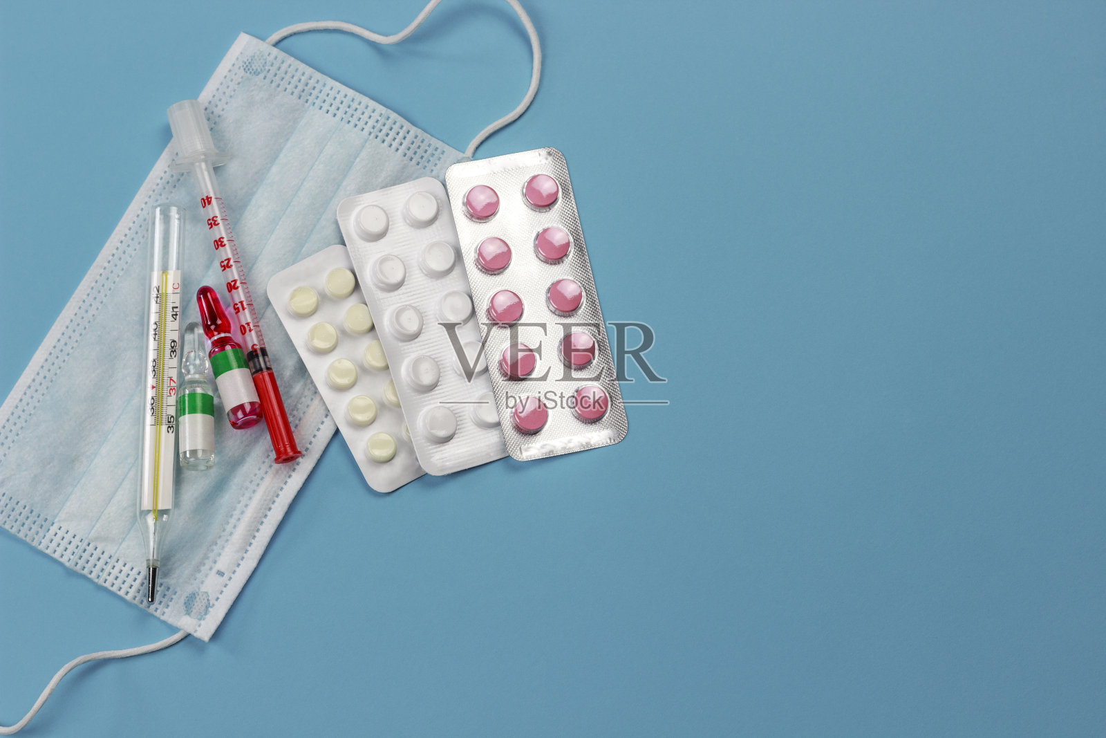 医用防护口罩，带药品、注射器和温度计，蓝色底色，副本spaсe照片摄影图片