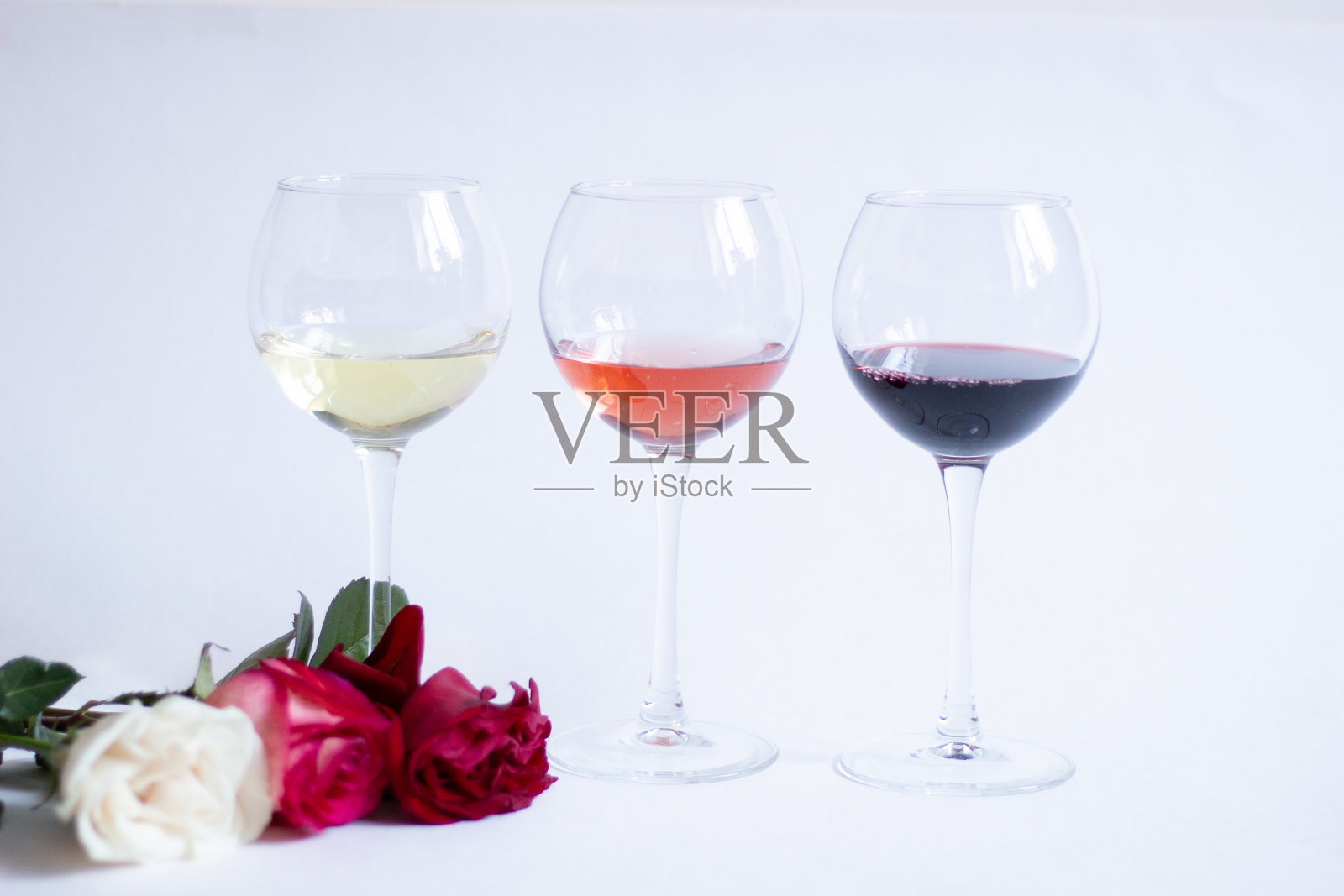 彩色的玫瑰花在白色的背景，白色，粉红色，红酒杯照片摄影图片