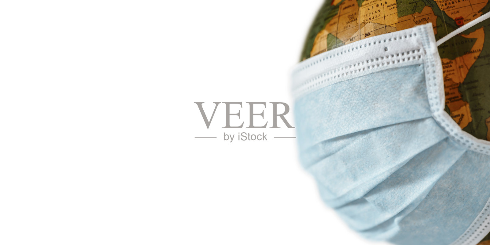 在白色背景上有面罩保护的隔离地球仪。世界医学概念。照片摄影图片