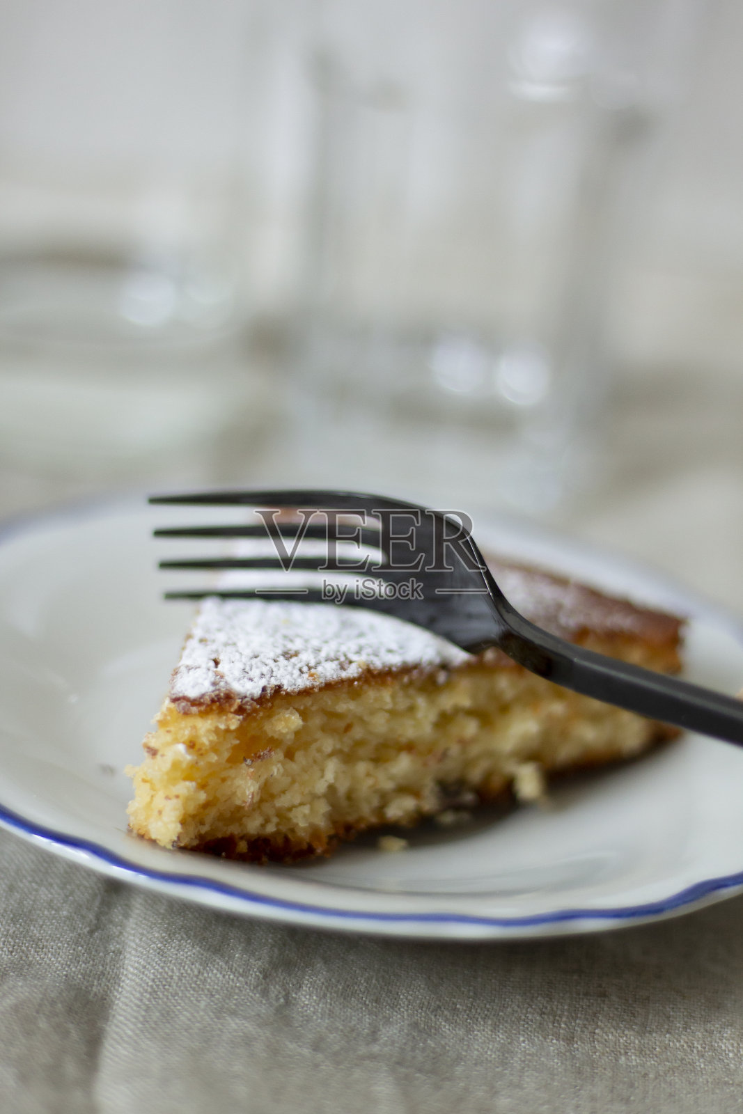 用叉子切一块用糖粉自制的酸奶蛋糕照片摄影图片