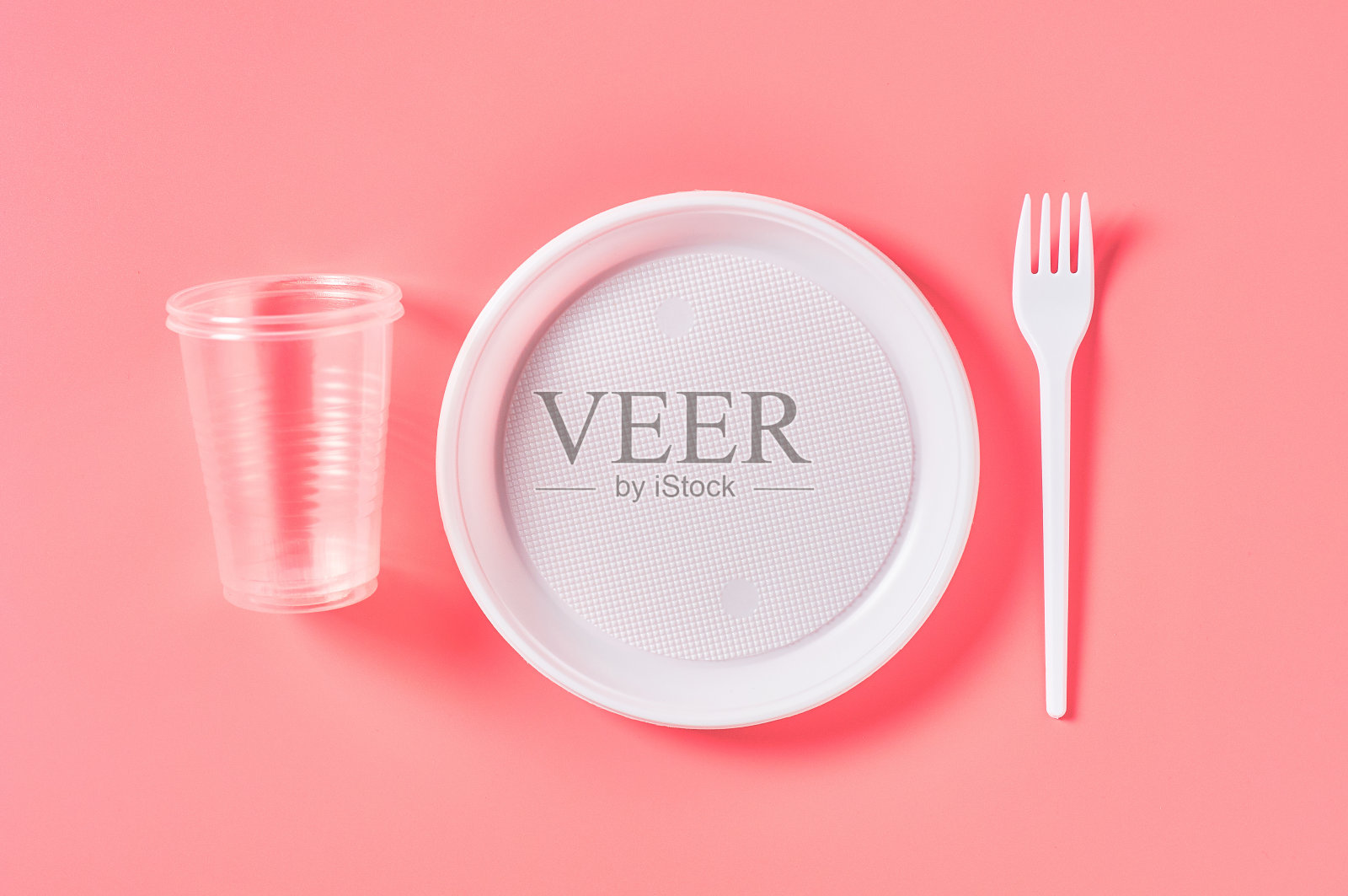 粉色背景的一次性塑料餐具。节约环境、生态、野餐、聚会等休闲活动的理念。俯视图照片摄影图片