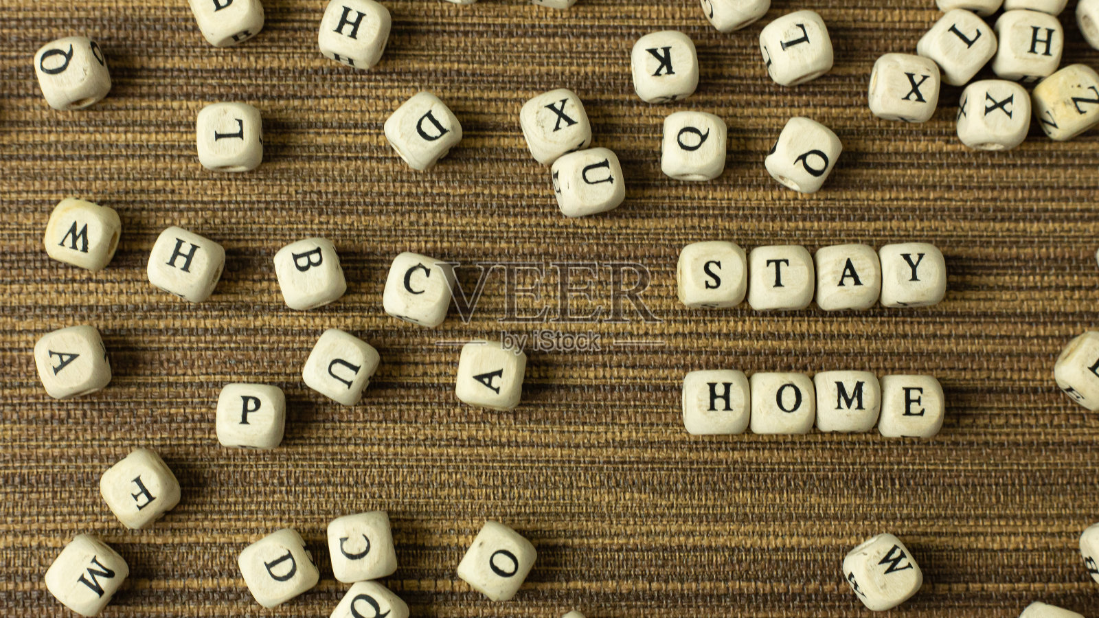 为了保持社交距离，呆在家里的木头立方体上。照片摄影图片