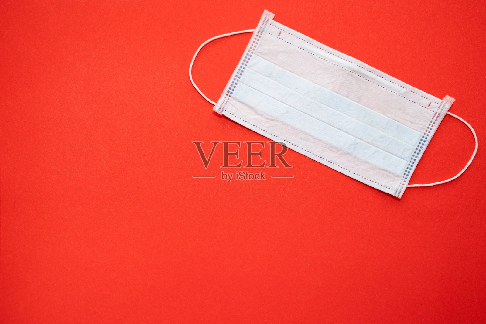 一次性医用口罩红色背景。本空间照片摄影图片