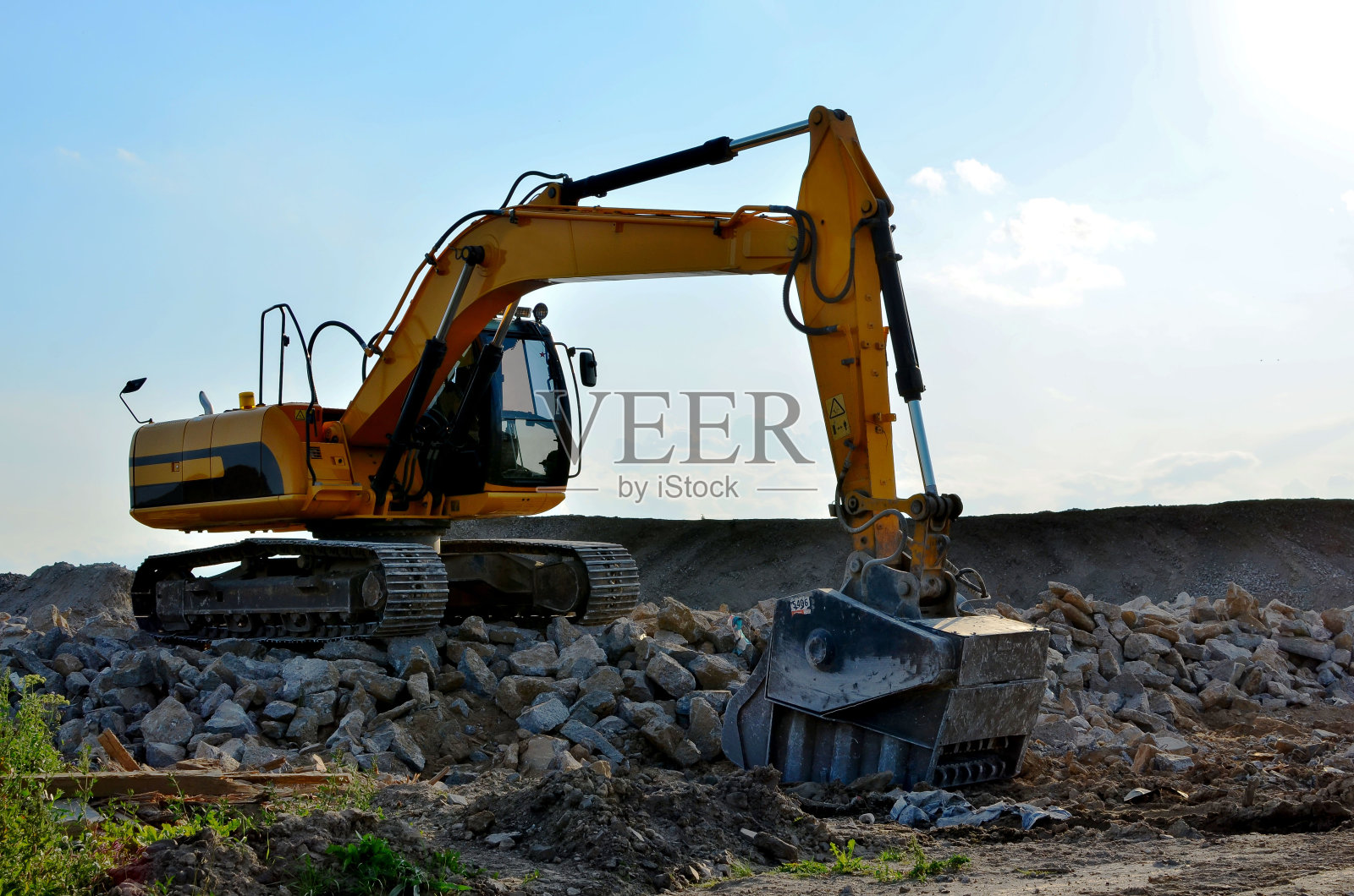 带有破碎斗的挖掘机用于破碎混凝土。建筑废料回收用于建筑配料。筛磨桶用于将混凝土分离成更高质量的组分。照片摄影图片