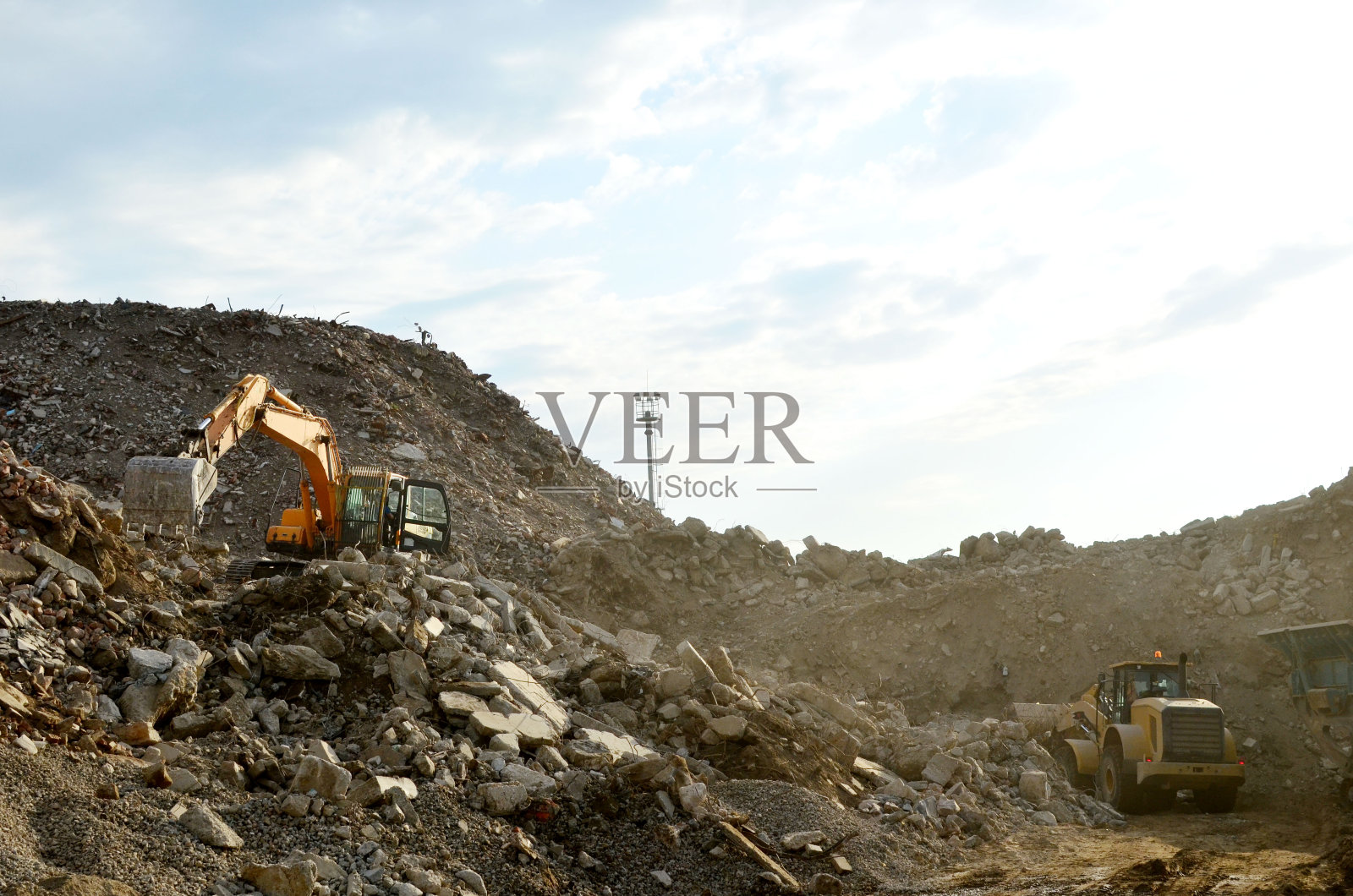 建筑及建筑材料之回收利用。工业废物处理厂。挖掘机及前端装载机在堆填区工作，处理拆卸混凝土废物。重用混凝土照片摄影图片