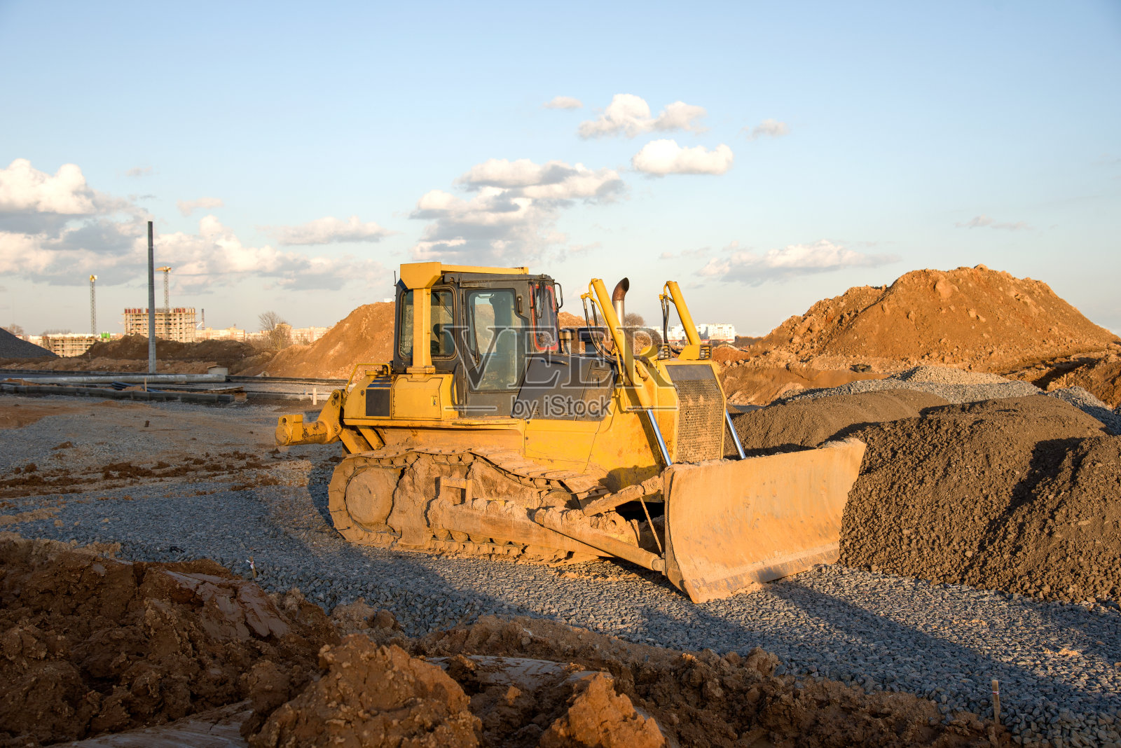 推土机在建筑工地工作。推土机用于清理土地，分级，挖掘水池，公用事业挖沟和基础挖掘。照片摄影图片