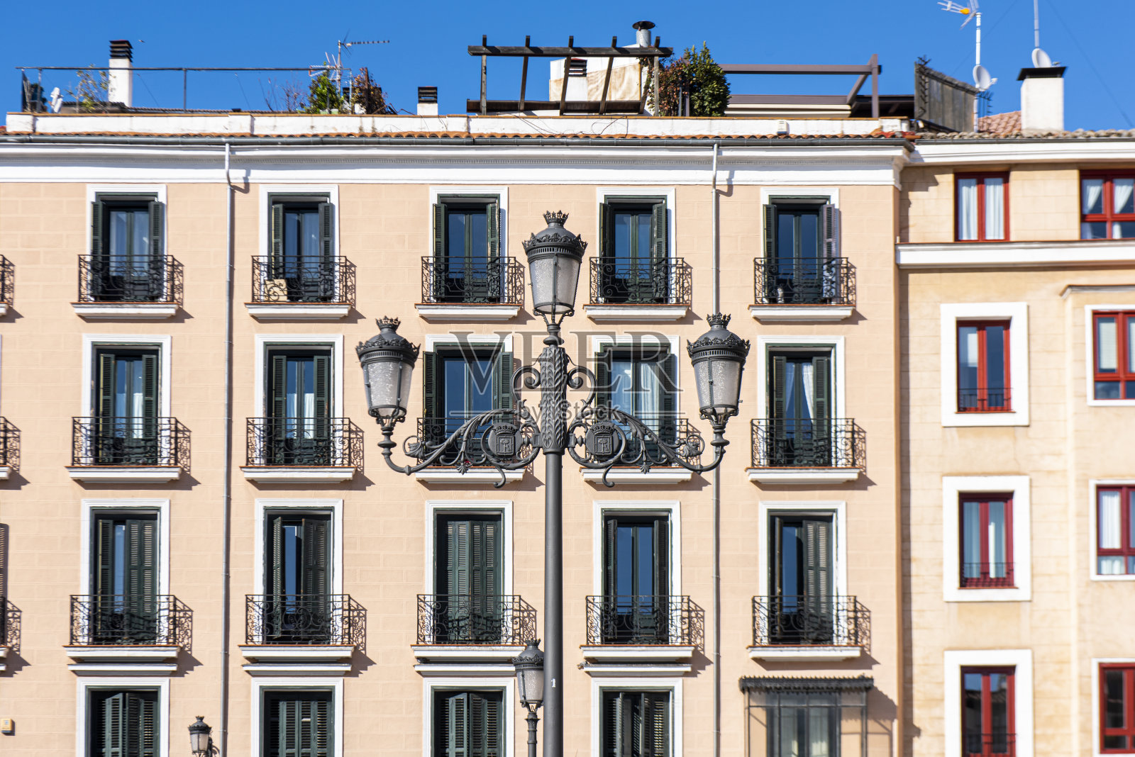 西班牙马德里市中心的一座古典建筑和一盏旧灯笼的正面上部。照片摄影图片