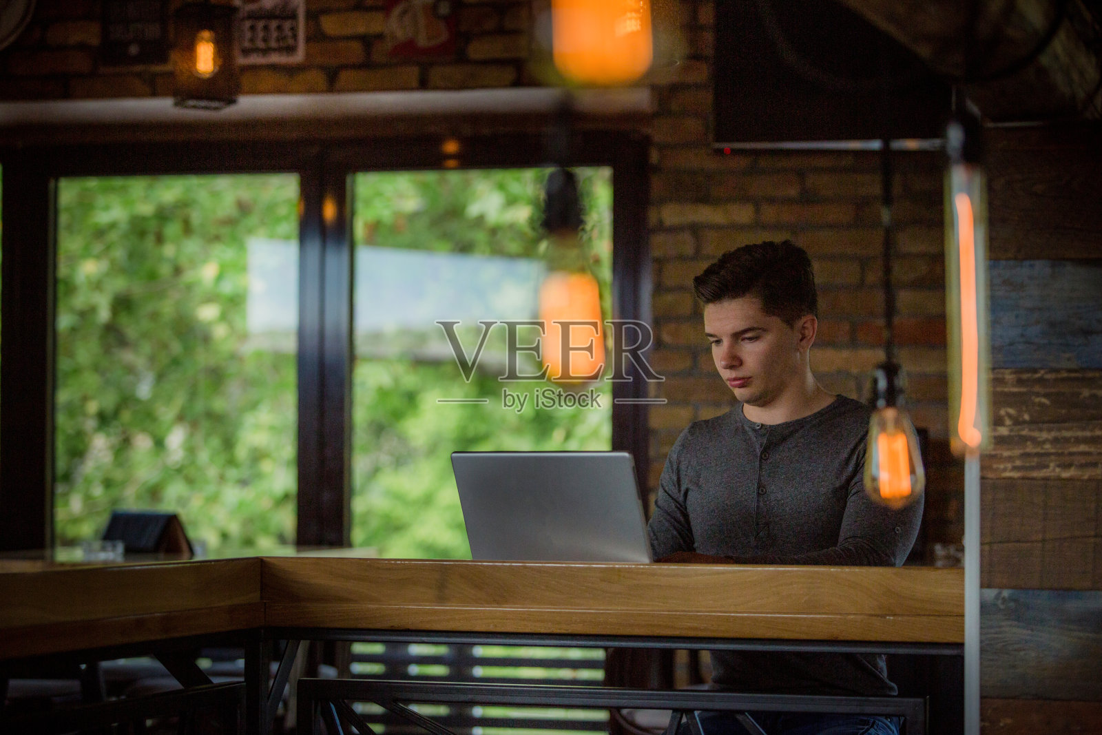 一个年轻人坐在咖啡馆里照片摄影图片