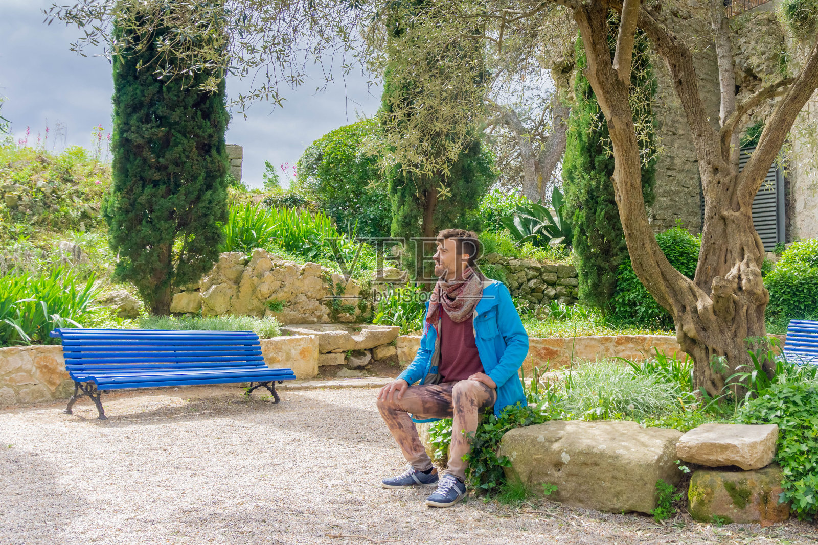 独自坐在公园长椅上的帅气男人照片摄影图片