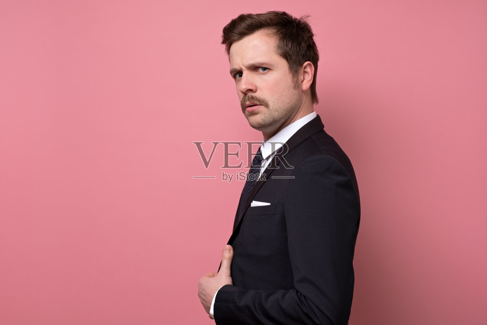 英俊严肃的男人，胡子和西装看着相机自信。照片摄影图片