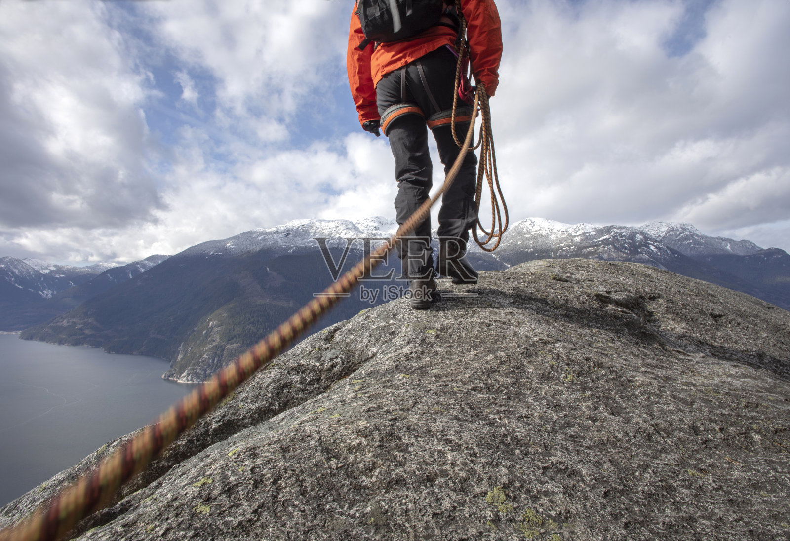 登山者拿着登山绳沿着山脊行走照片摄影图片
