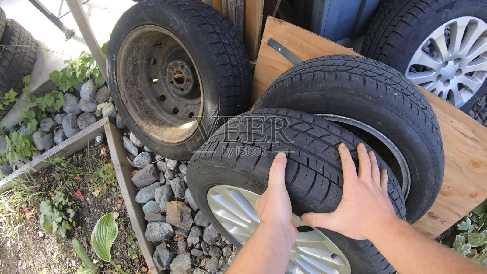 POV过去的手抓汽车车轮从堆照片摄影图片