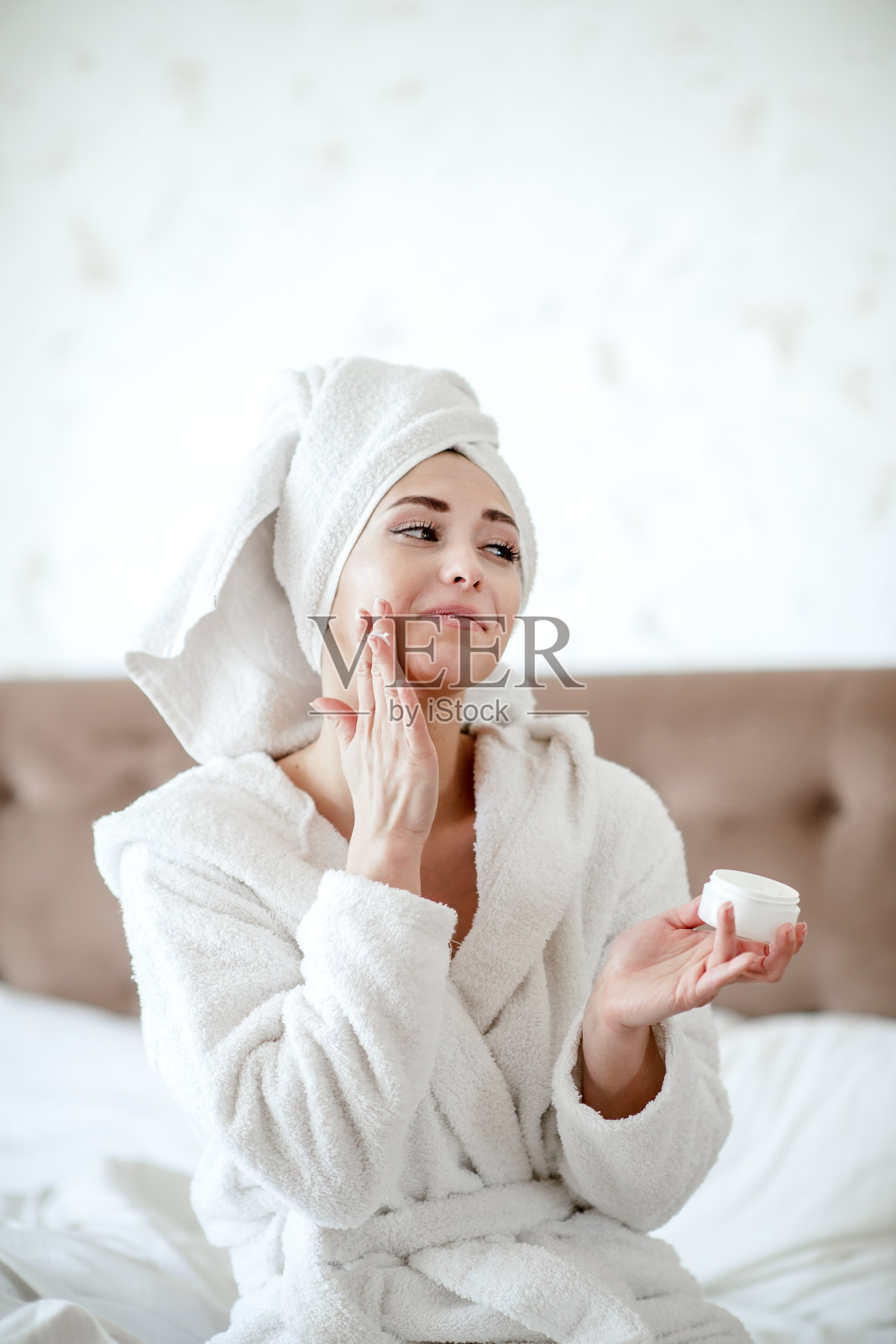 在脸上涂保湿霜的女人照片摄影图片