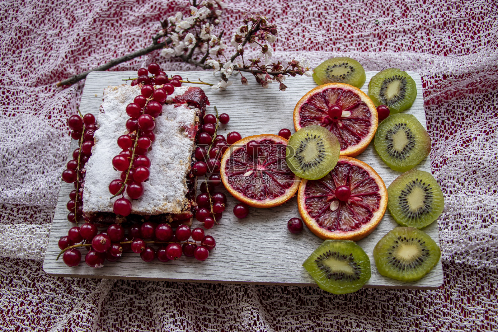 红木桌，天然健康水果拼盘:勃艮第蓝莓，橙子，猕猴桃，香蕉，菠萝，葡萄柚，草莓，红橙配鲜叶。照片摄影图片