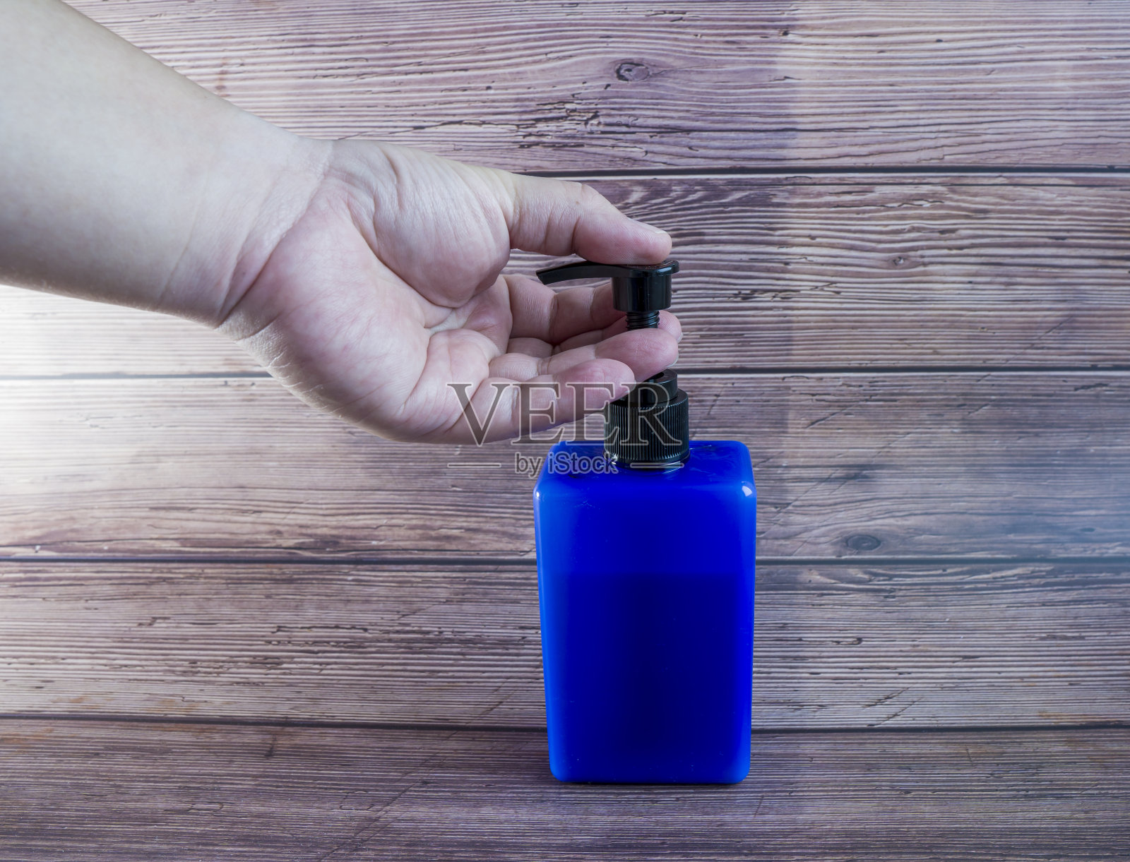 双手使用洗手液、凝胶泵、分配器。泵瓶内装有清洁消毒剂，用于杀菌、细菌和病毒。照片摄影图片