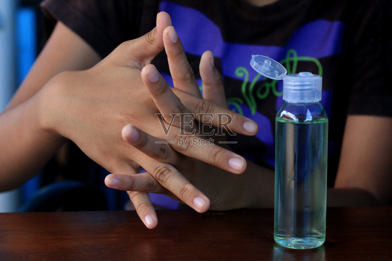 使用酒精凝胶洗手液清洁双手，预防covid-19冠状病毒。照片摄影图片