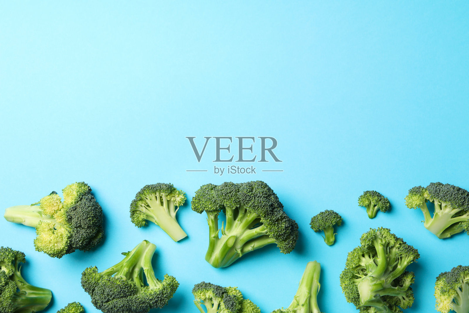 西兰花在蓝色背景，俯视图。健康的食物照片摄影图片