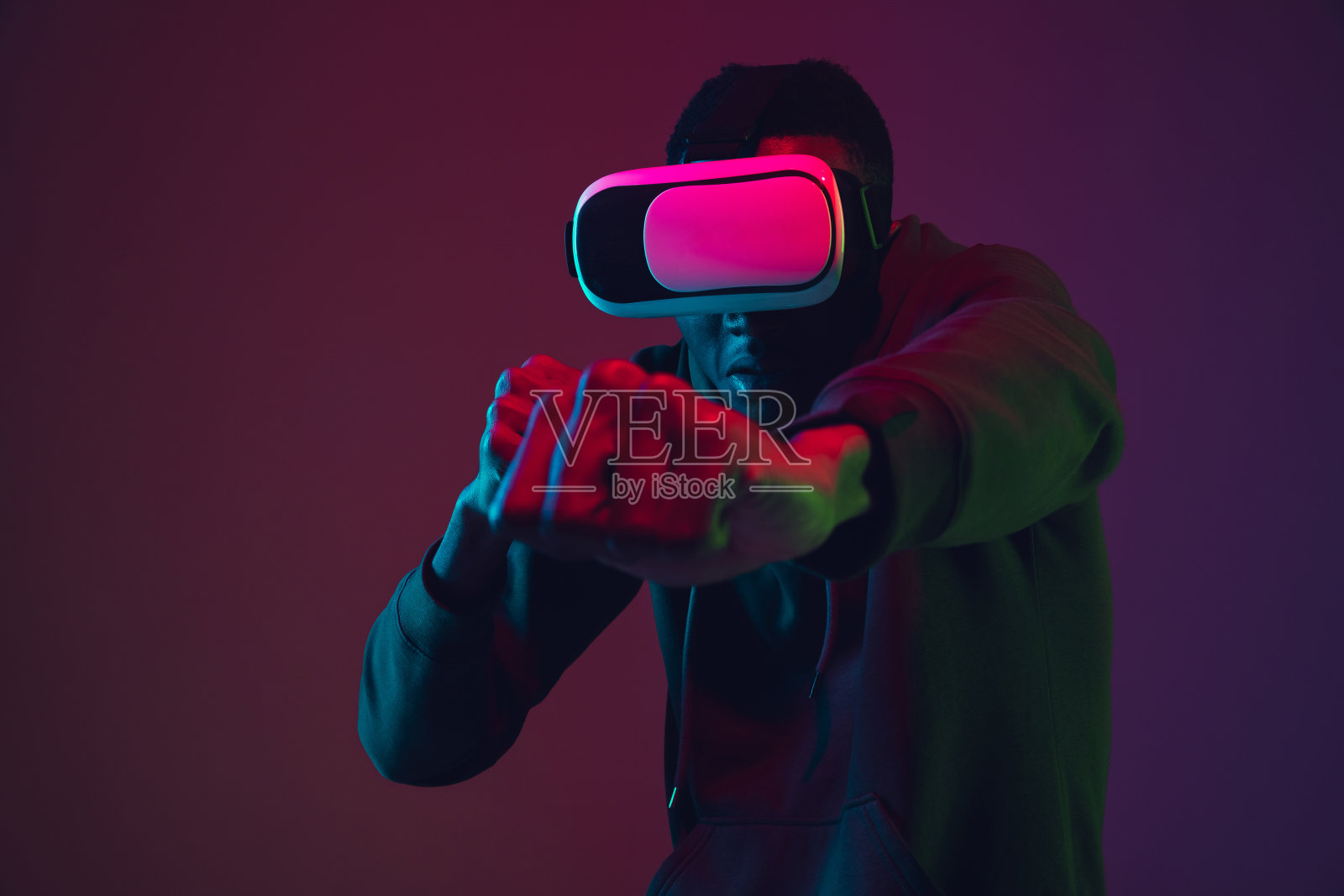 非裔美国人的肖像在vr耳机孤立在梯度工作室背景霓虹灯照片摄影图片