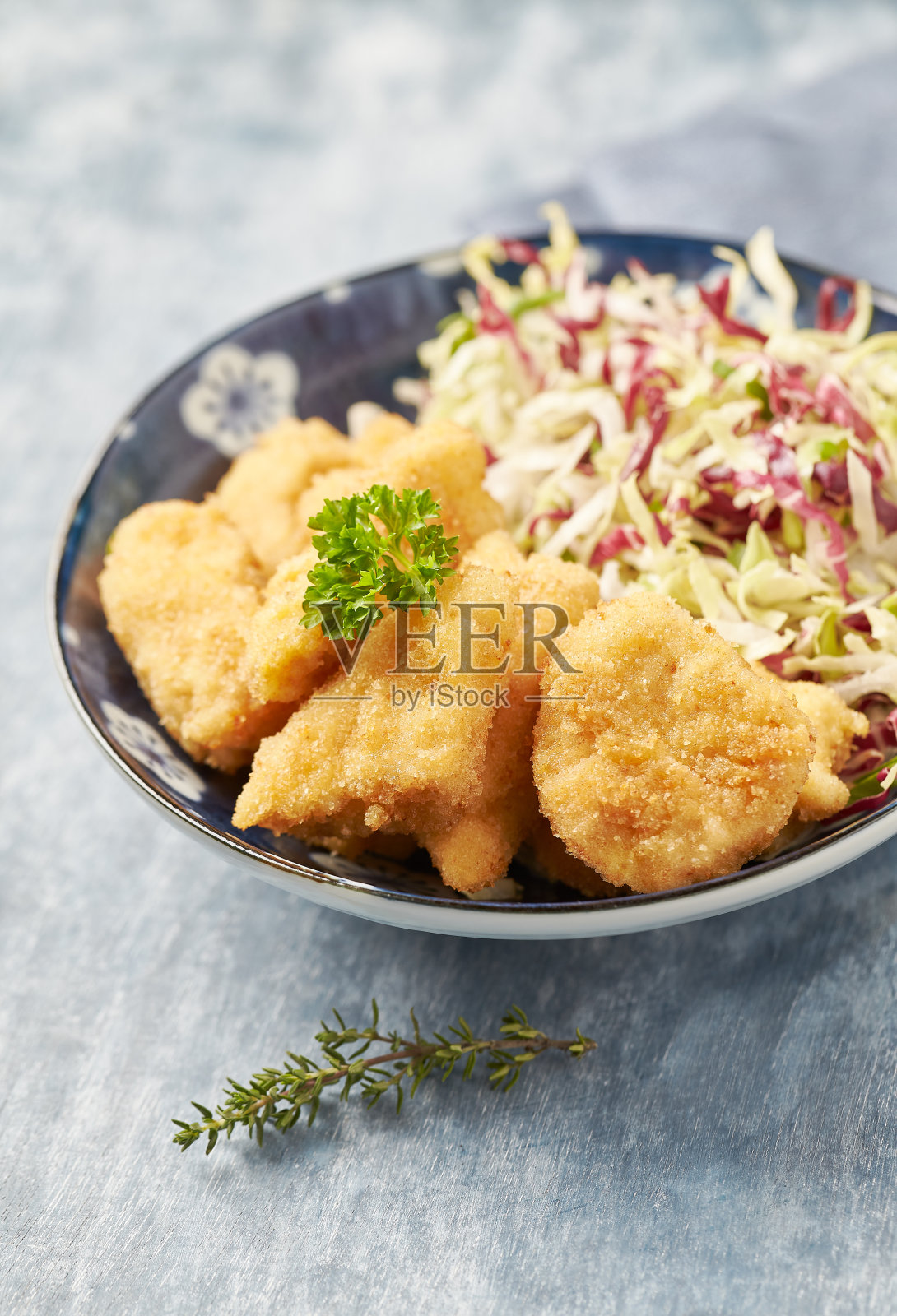 鸡块配生沙拉和炸薯条，背景是明亮的木头。照片摄影图片