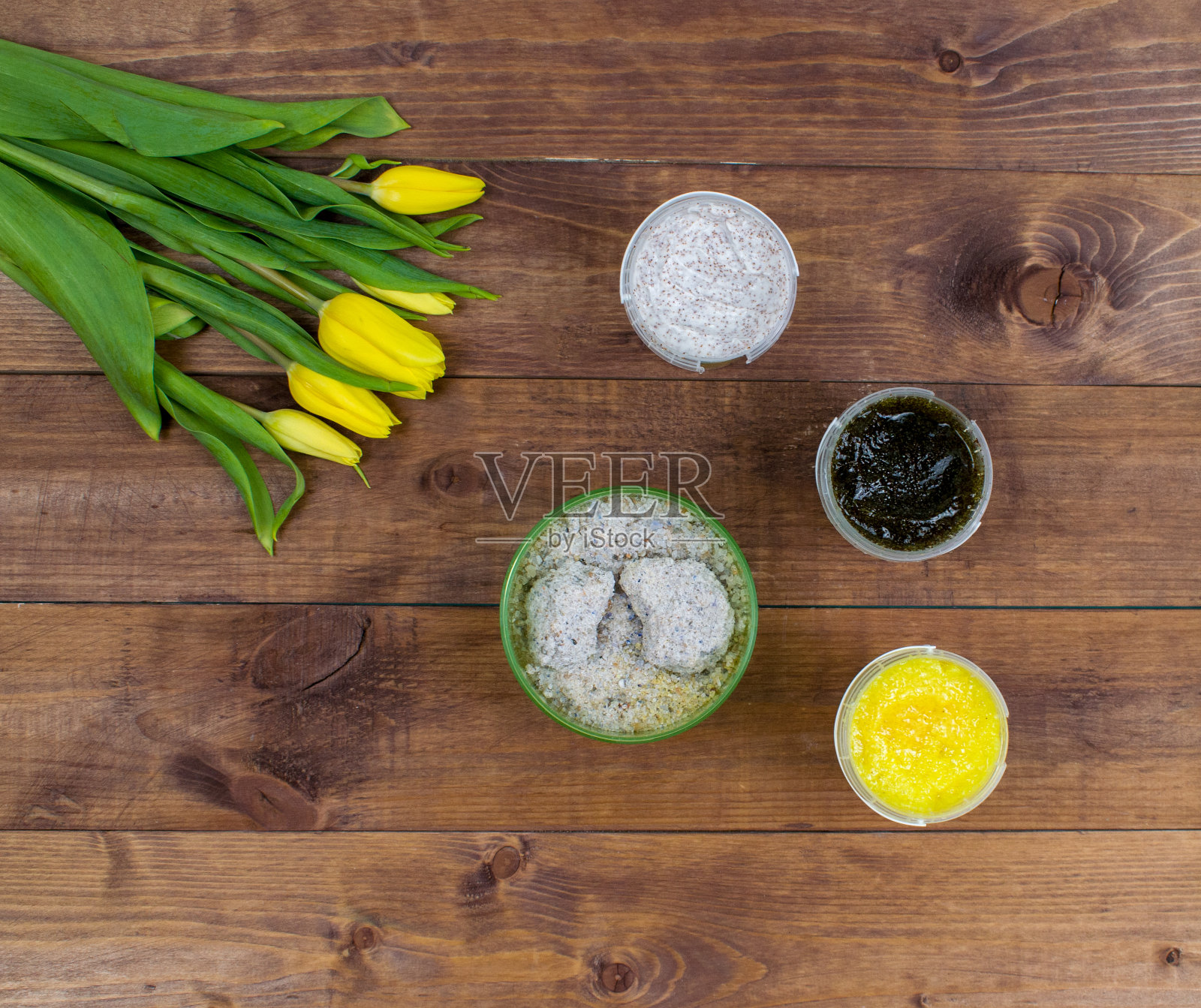 扁平风格春季复活节郁金香花束与化妆品。身体磨砂膏和海盐套装。顶部视角的化妆品扁平风格照片摄影图片