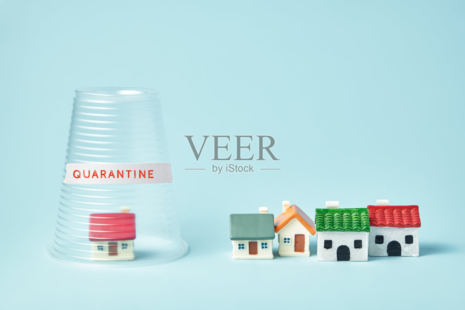 冠状病毒检疫的概念。小房子上盖着透明的塑料杯和题字检疫照片摄影图片