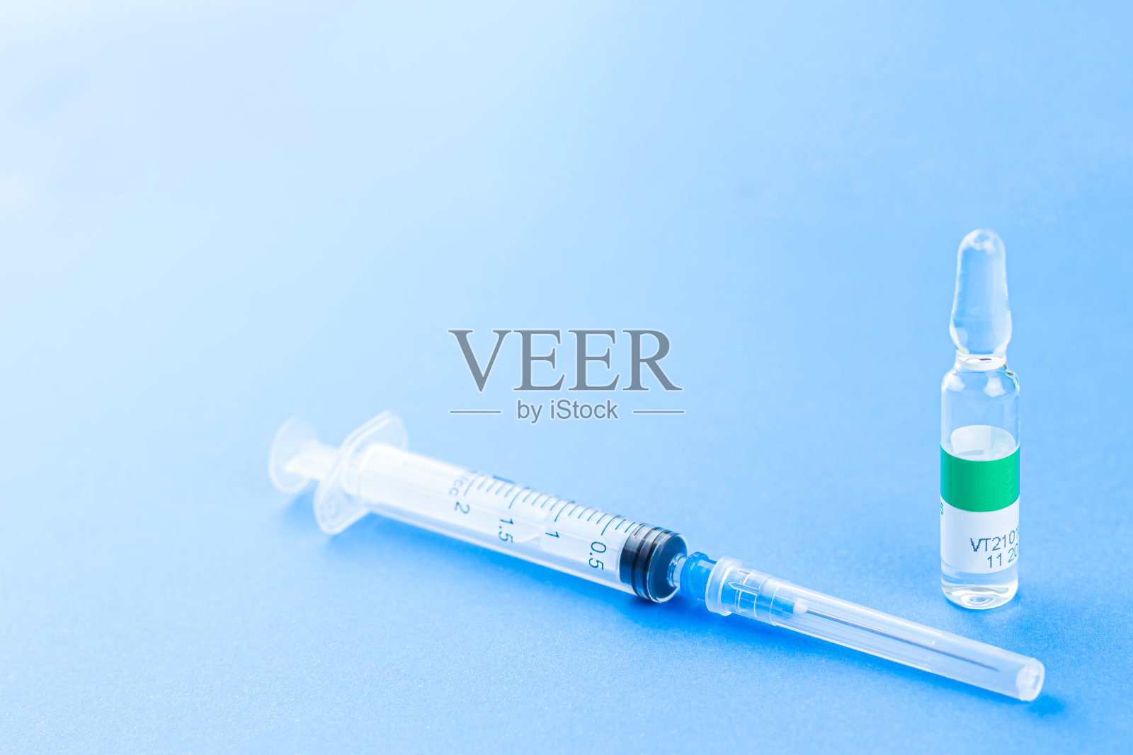 冠状病毒Covid-19疫苗概念，蓝色背景注射器照片摄影图片